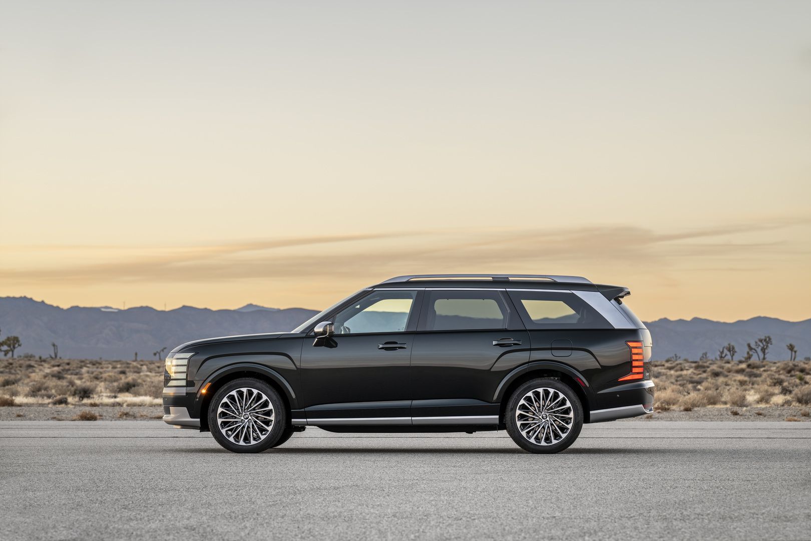2026 Hyundai Palisade Hybrid - side profile view of the dark green 2026 Hyundai Palisade Hybrid parked at dusk - Woodstock Hyundai - New car dealership in Woodstock, Ontario