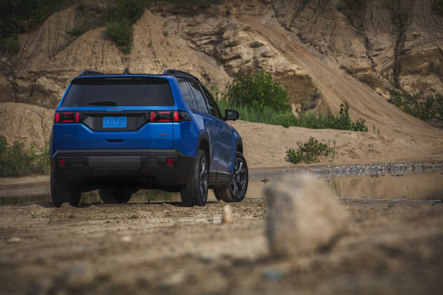 2026 Jeep Cherokee - Rear three-quarter view of a blue 2026 Jeep Cherokee parked on a sandy trail - Humberview Group - New car dealerships in Ontario