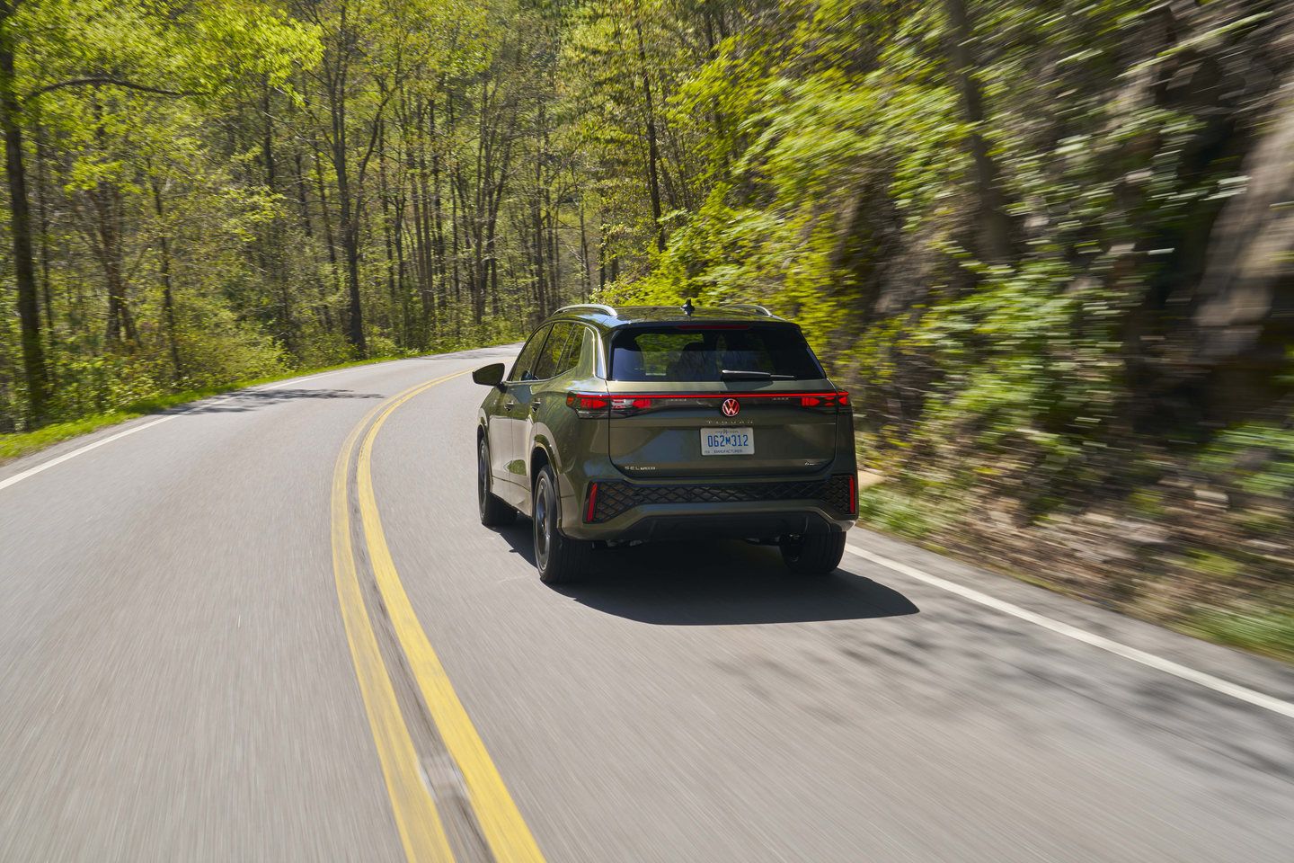 2026 Volkswagen Tiguan - rear view while driving on a forested road - Mid-Town Volkswagen - New car dealership in Toronto, Ontario