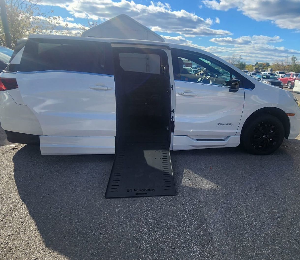 2026 Honda Odyssey - side view of a white 2026 Honda Odyssey with a BraunAbility side-entry ramp deployed - Courtland Mobility - Accessible car dealership in Burlington, Ontario