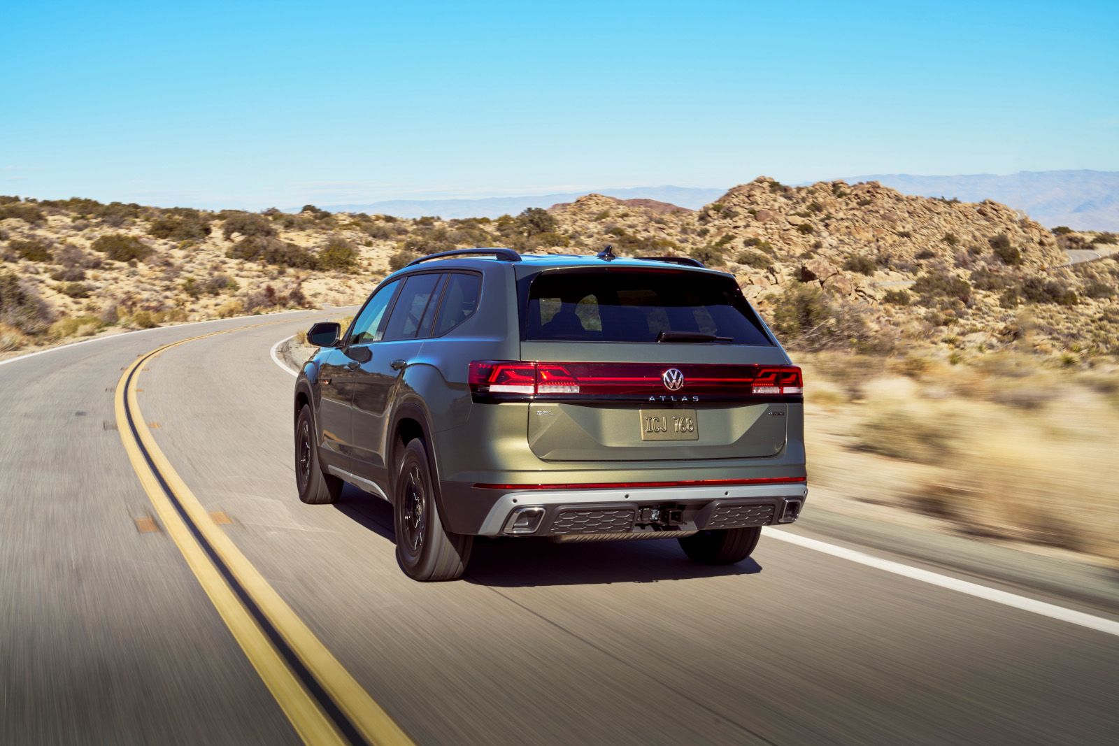 2026 Volkswagen Atlas Peak Edition - rear view of an Avocado Green 2026 Volkswagen Atlas Peak Edition driving on a road - Humberview Volkswagen - New car dealership in Toronto, Ontario