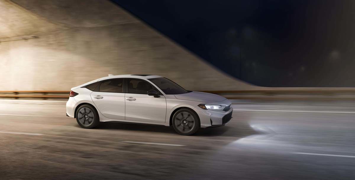 2026 Honda Civic Hatchback - a white 2026 Honda Civic Hatchback driving through a tunnel at night - Goderich Honda - New car dealership in Goderich, Ontario