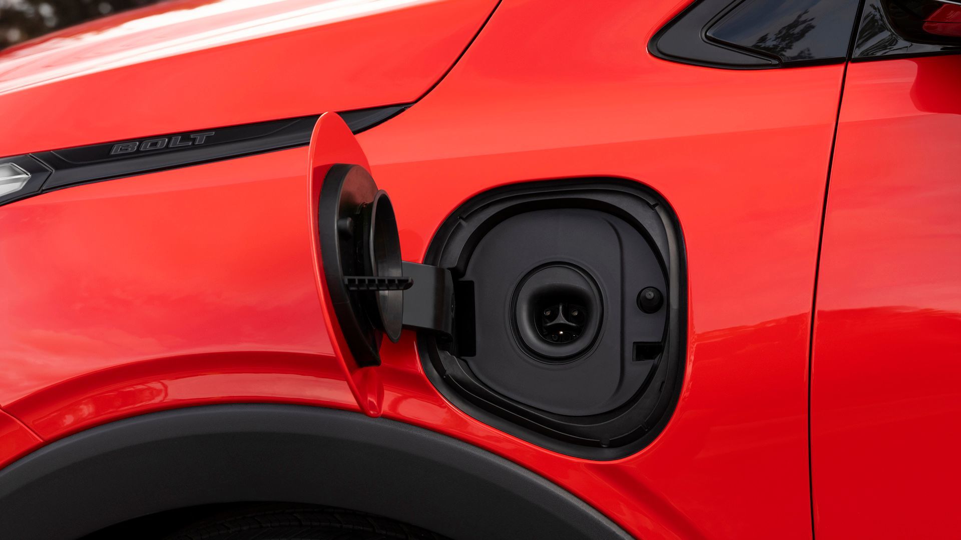 2026 Chevrolet Bolt - close-up view of the open charge port on a red Chevrolet Bolt - Applewood Chevrolet, Buick, GMC - New car dealership in Mississauga, Ontario