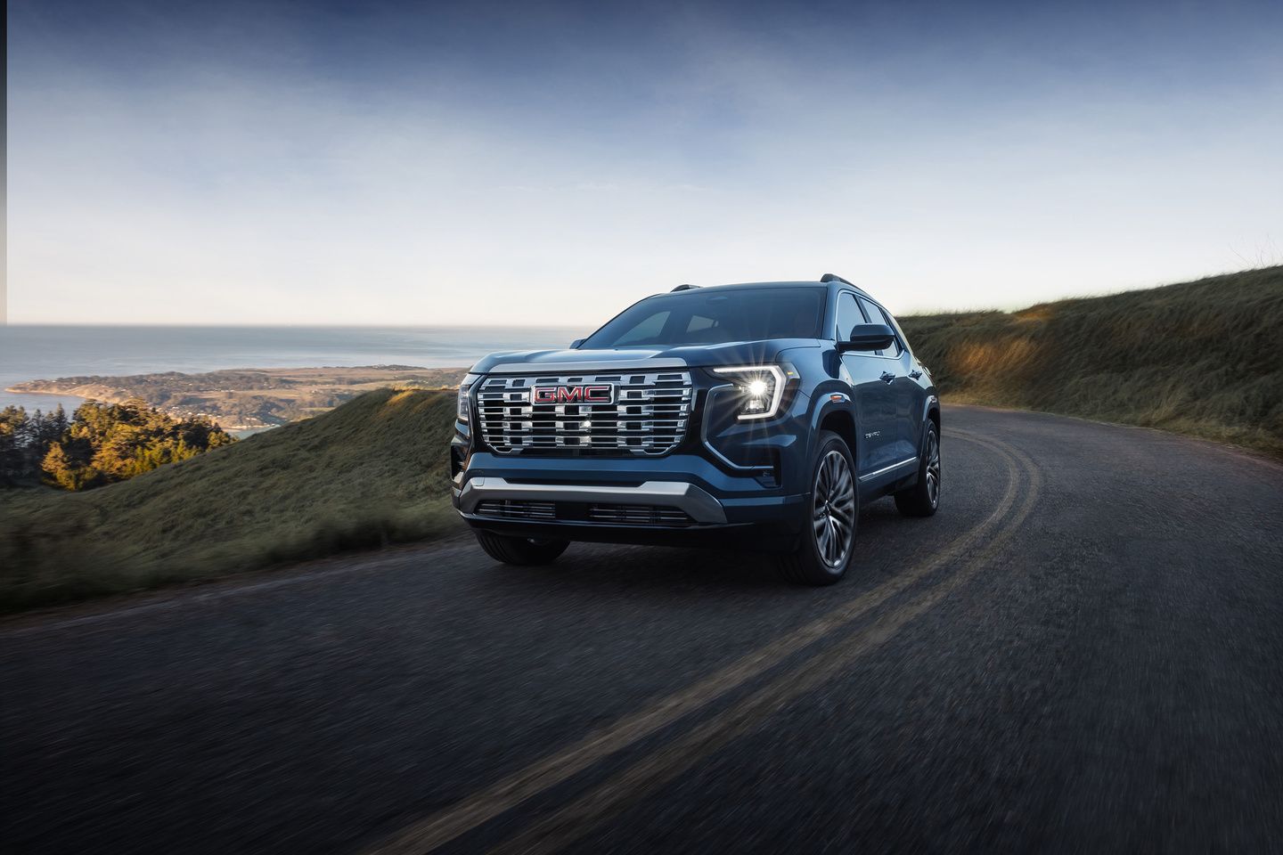 2026 GMC Terrain - front view of a blue GMC Terrain driving on a winding road - Applewood Chevrolet, Buick, GMC - New car dealership in Mississauga, Ontario