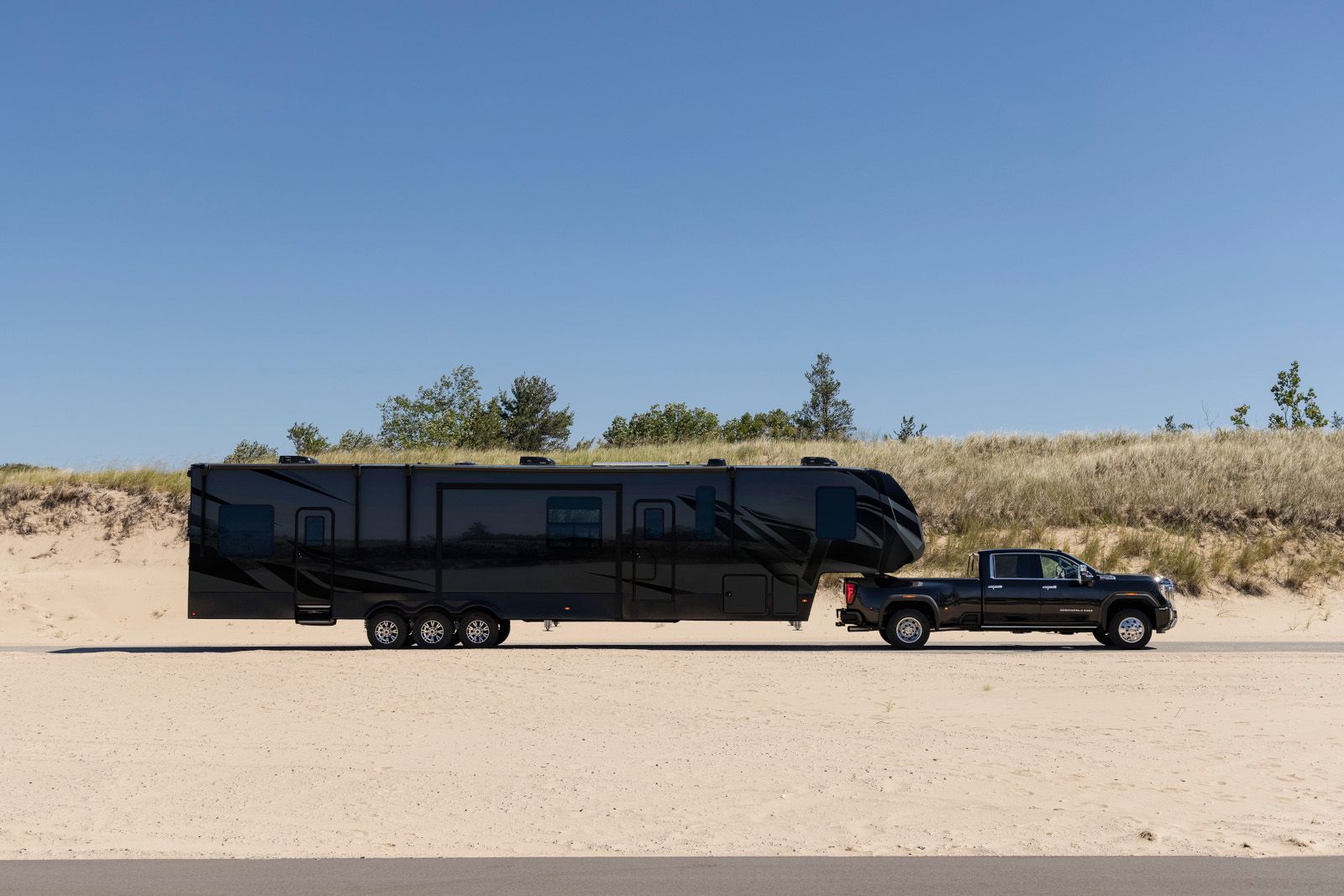 2026 GMC Sierra 3500 HD - side profile of the truck towing a large luxury camping trailer - Humberview Chevrolet, Buick, GMC - New car dealership in Toronto, Ontario