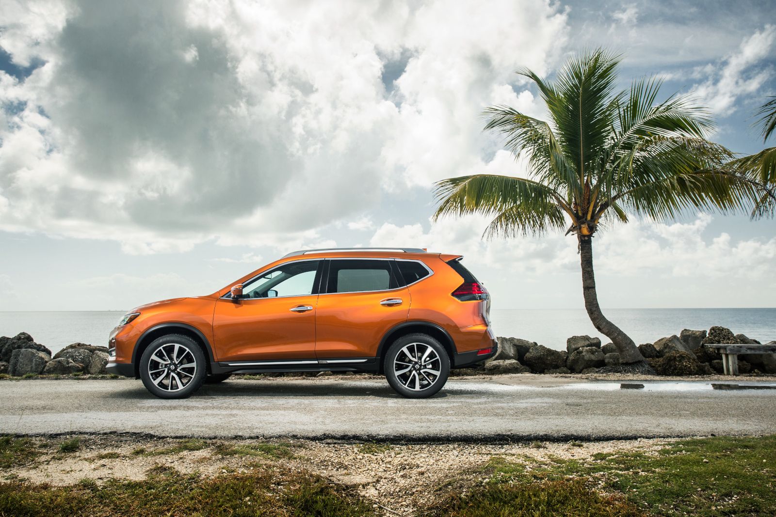 Nissan Rogue - side view of an orange Nissan Rogue parked near the ocean - AutoPark Brampton - Accessible car dealership in Brampton, Ontario