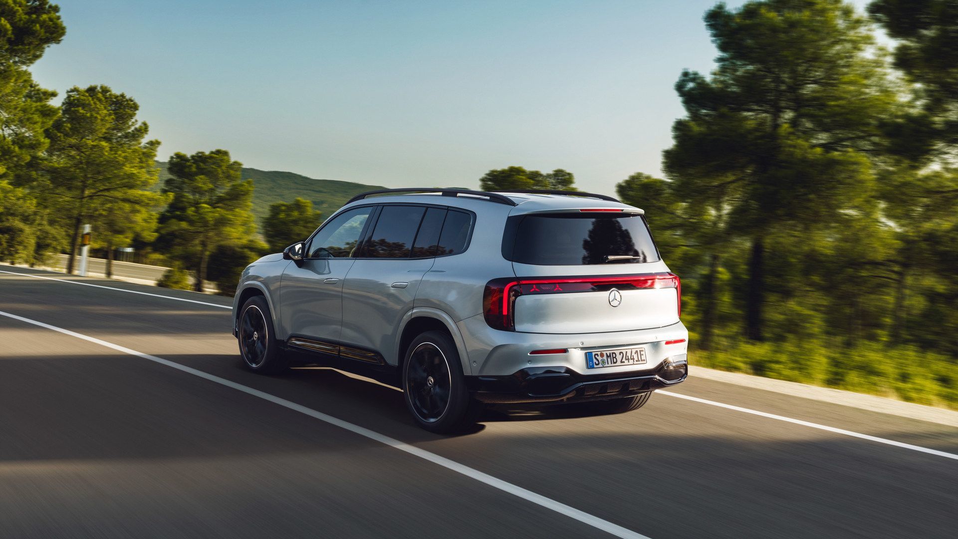 2026 Mercedes-Benz EQB - rear view of a silver 2026 Mercedes-Benz EQB driving on a paved highway - Mercedes-Benz Brampton - New car dealership in Brampton, Ontario