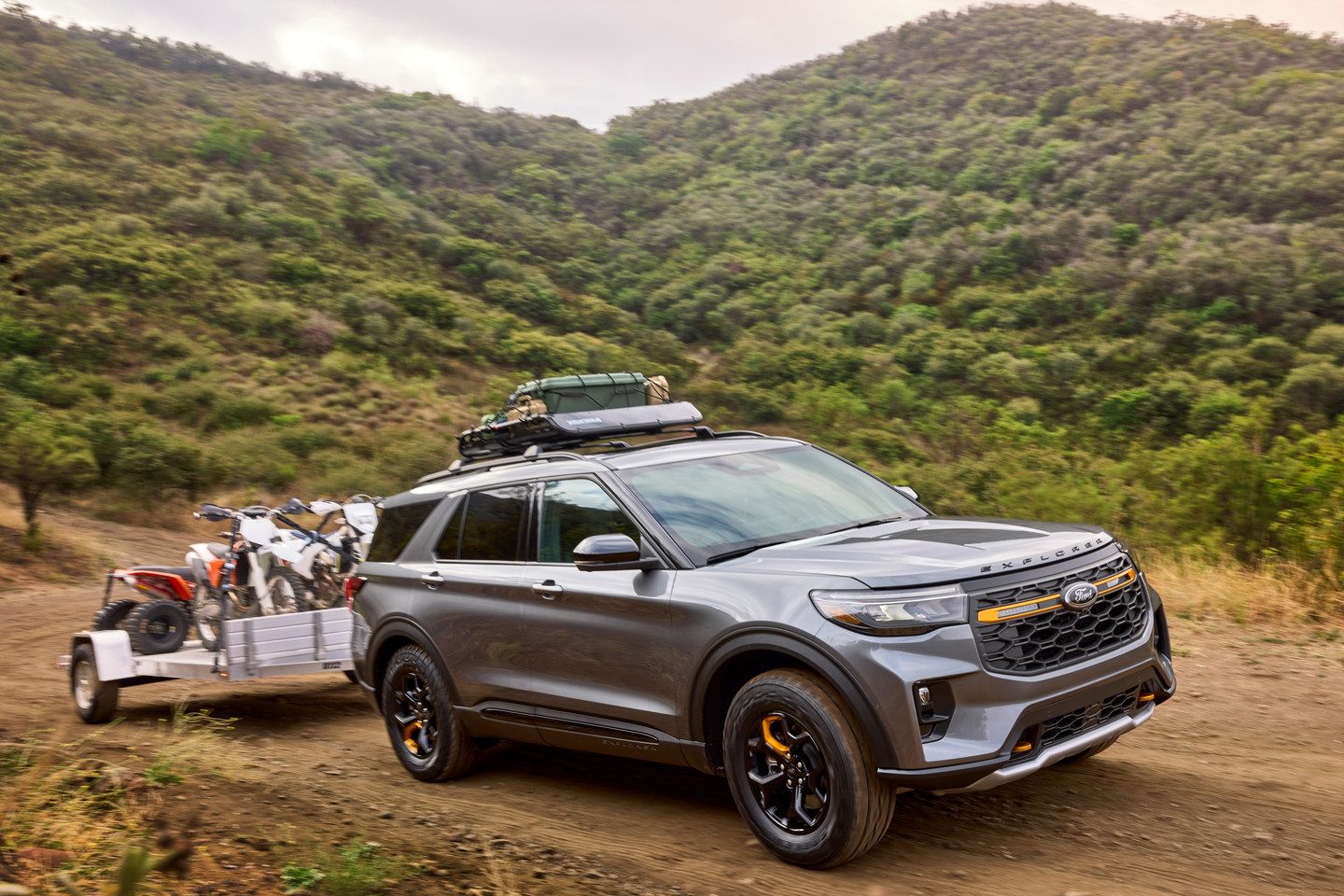 2026 Ford Explorer Tremor - a grey 2026 Ford Explorer Tremor towing a trailer on a dirt trail - Humberview Group - New car dealerships in Ontario