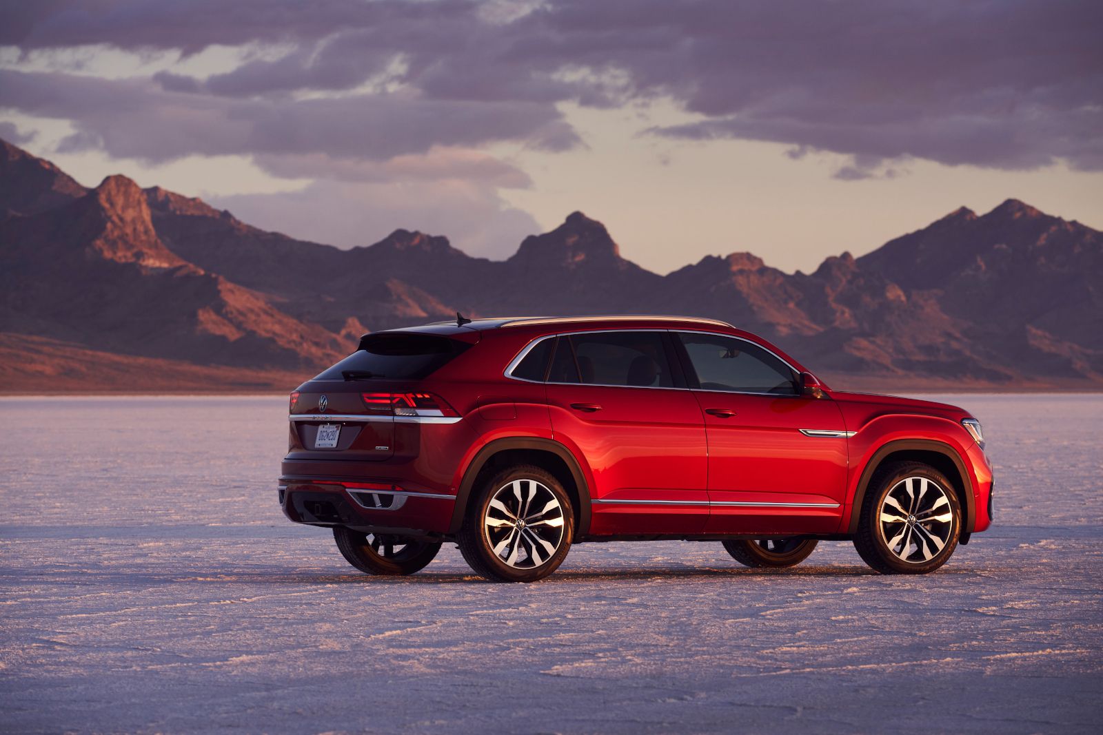 Volkswagen Atlas Cross Sport - rear view of a red Volkswagen Atlas Cross Sport parked on a salt flat with mountains in the background - Autopark Barrie - Used car dealership in Barrie, Ontario