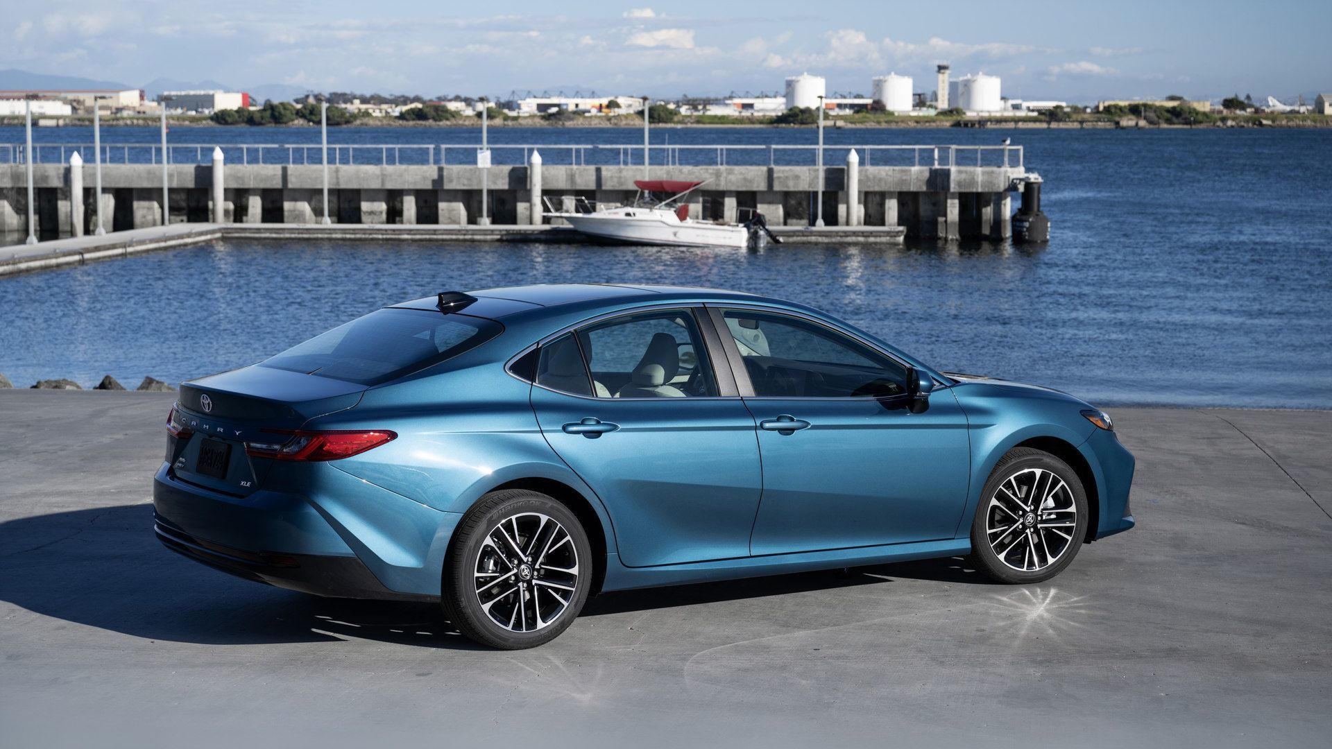 2026 Toyota Camry - rear three-quarter view of a blue Toyota Camry parked near a waterfront pier - Goderich Toyota - New car dealership in Goderich, Ontario