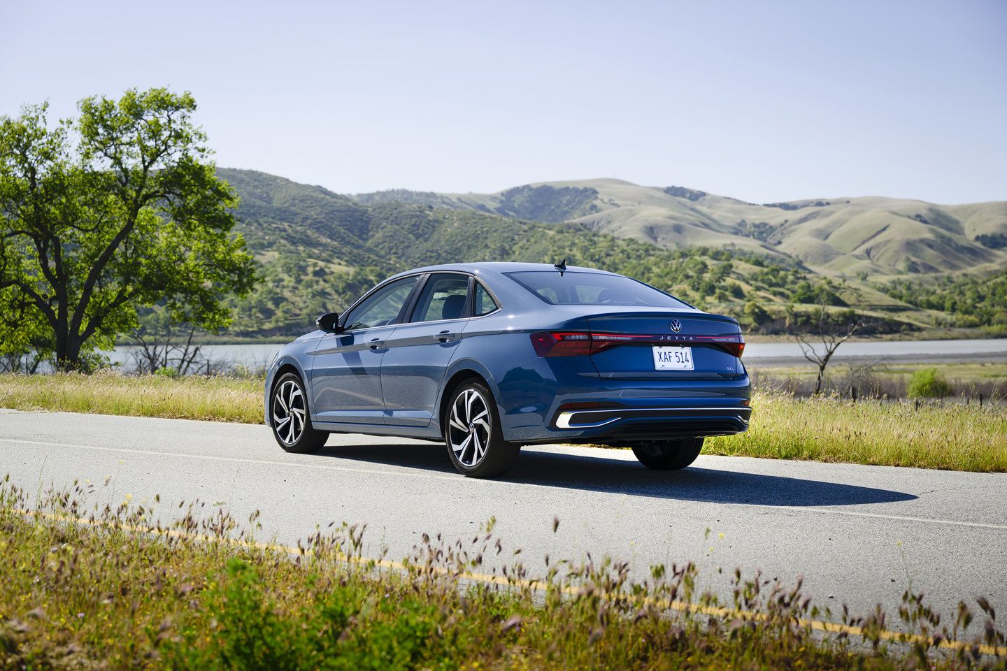 2026 Volkswagen Jetta - rear three-quarter view of a blue Volkswagen Jetta on a scenic road - Humberview Volkswagen - New car dealership in Toronto, Ontario