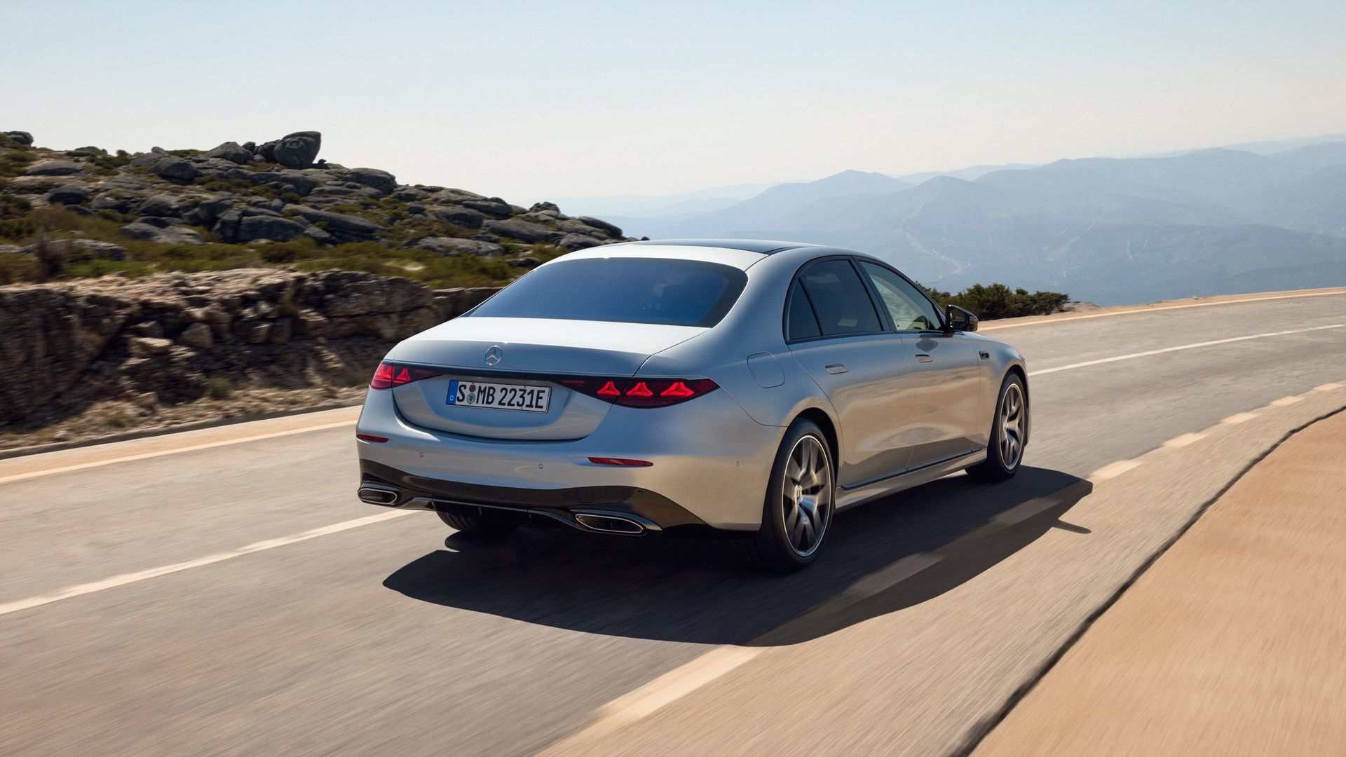 2026 Mercedes-Benz S-Class - rear view of a silver 2026 Mercedes-Benz S-Class driving on a mountain road - Mercedes-Benz Brampton - New car dealership in Brampton, Ontario