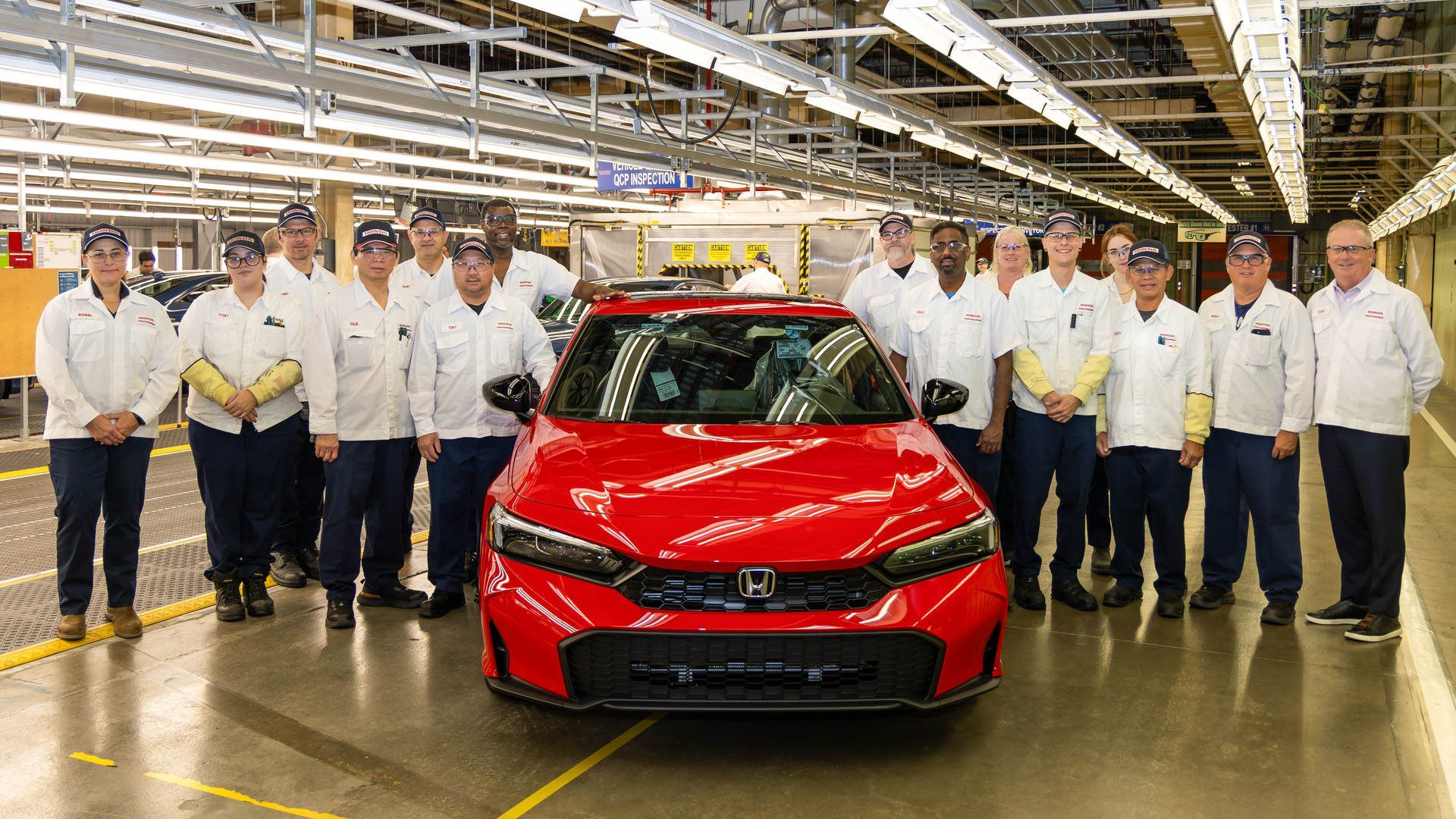 2026 Honda Civic - a red 2026 Honda Civic surrounded by a team of manufacturing assembly workers in the Ontario factory - Goderich Honda - Honda new car dealership in Goderich, Ontario