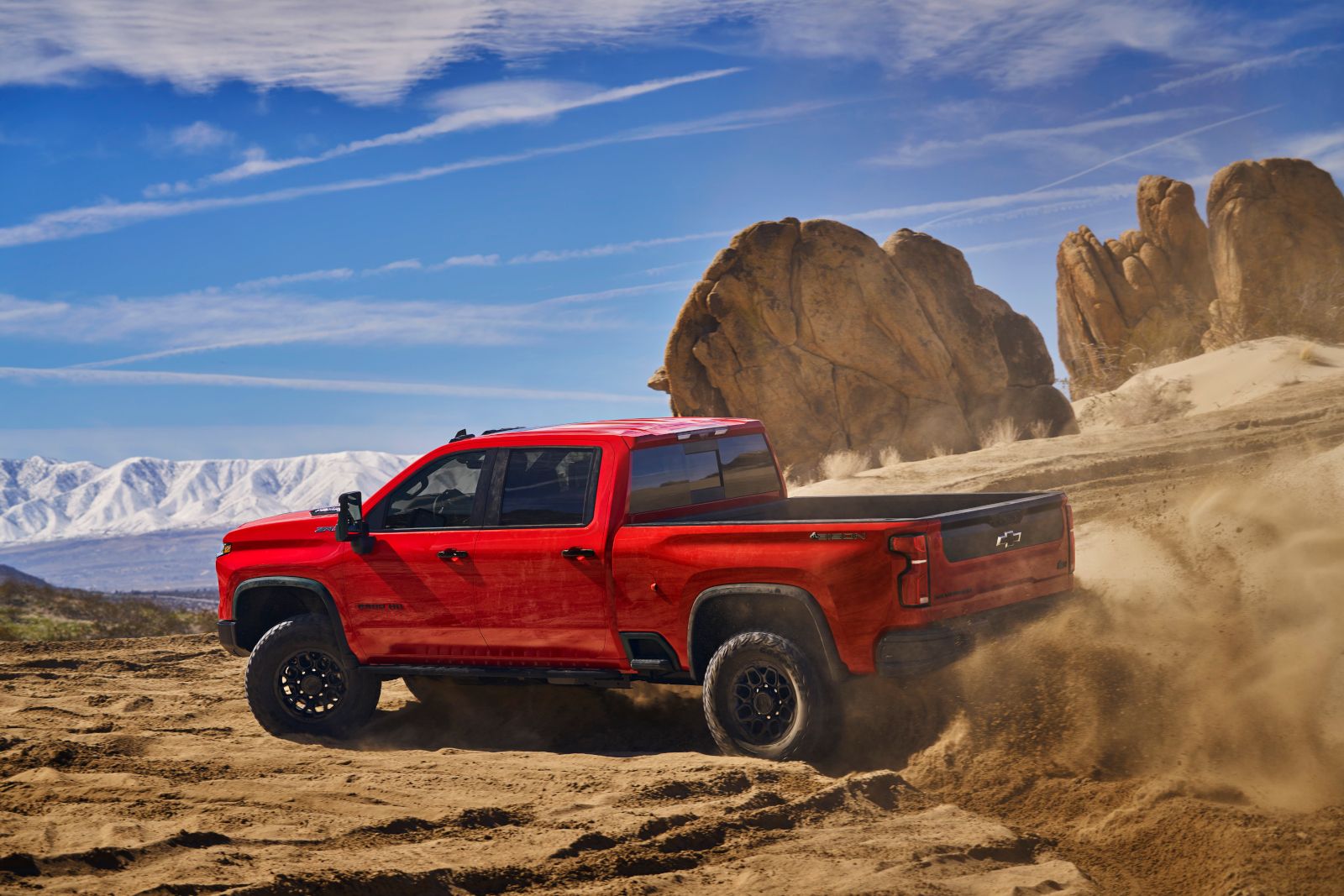 2026 Chevrolet Silverado 2500HD ZR2 Bison - a red 2026 Chevrolet Silverado HD ZR2 Bison kicking up sand while driving off-road in the desert - City Chevrolet, Buick, GMC - New car dealership in Toronto, Ontario