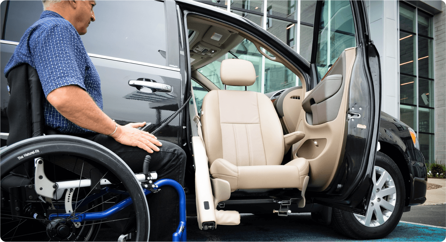 Side view of a person in a wheelchair using an automated swivel seat to enter a black minivan - Courtland Mobility - Accessible car dealership in Burlington, Ontario