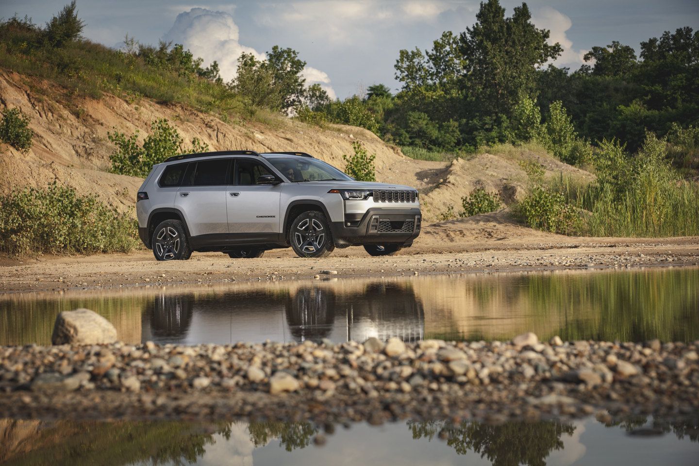 2026 Jeep Cherokee - side profile of a silver 2026 Jeep Cherokee parked in a sandy quarry - Cooksville Dodge - Jeep new car dealership in Mississauga, Ontario
