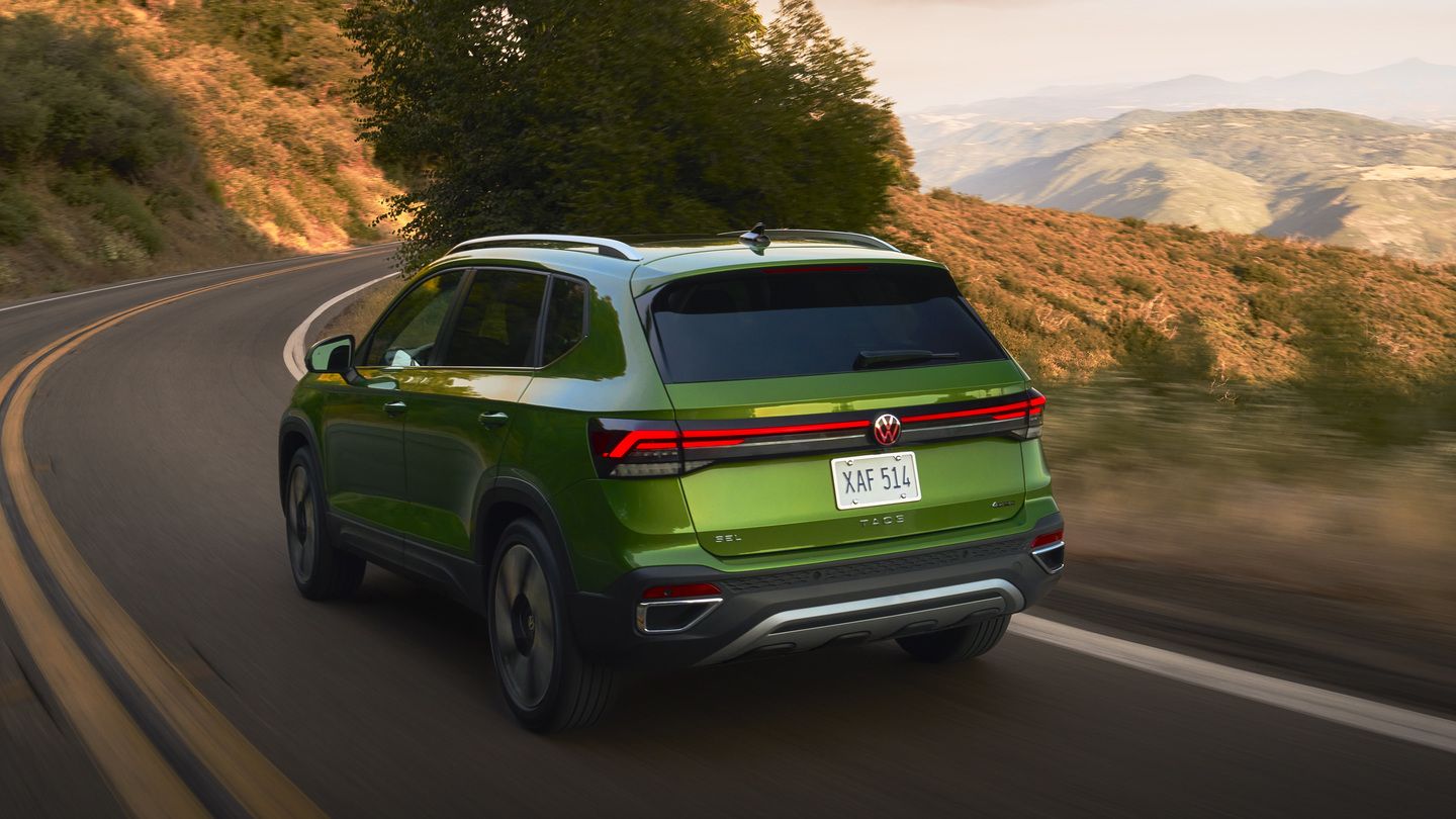 2026 Volkswagen Taos - rear view of a bright green 2026 Volkswagen Taos SEL driving on a winding mountain road - Volkswagen Mid-Town Toronto - New car dealership in Toronto, Ontario