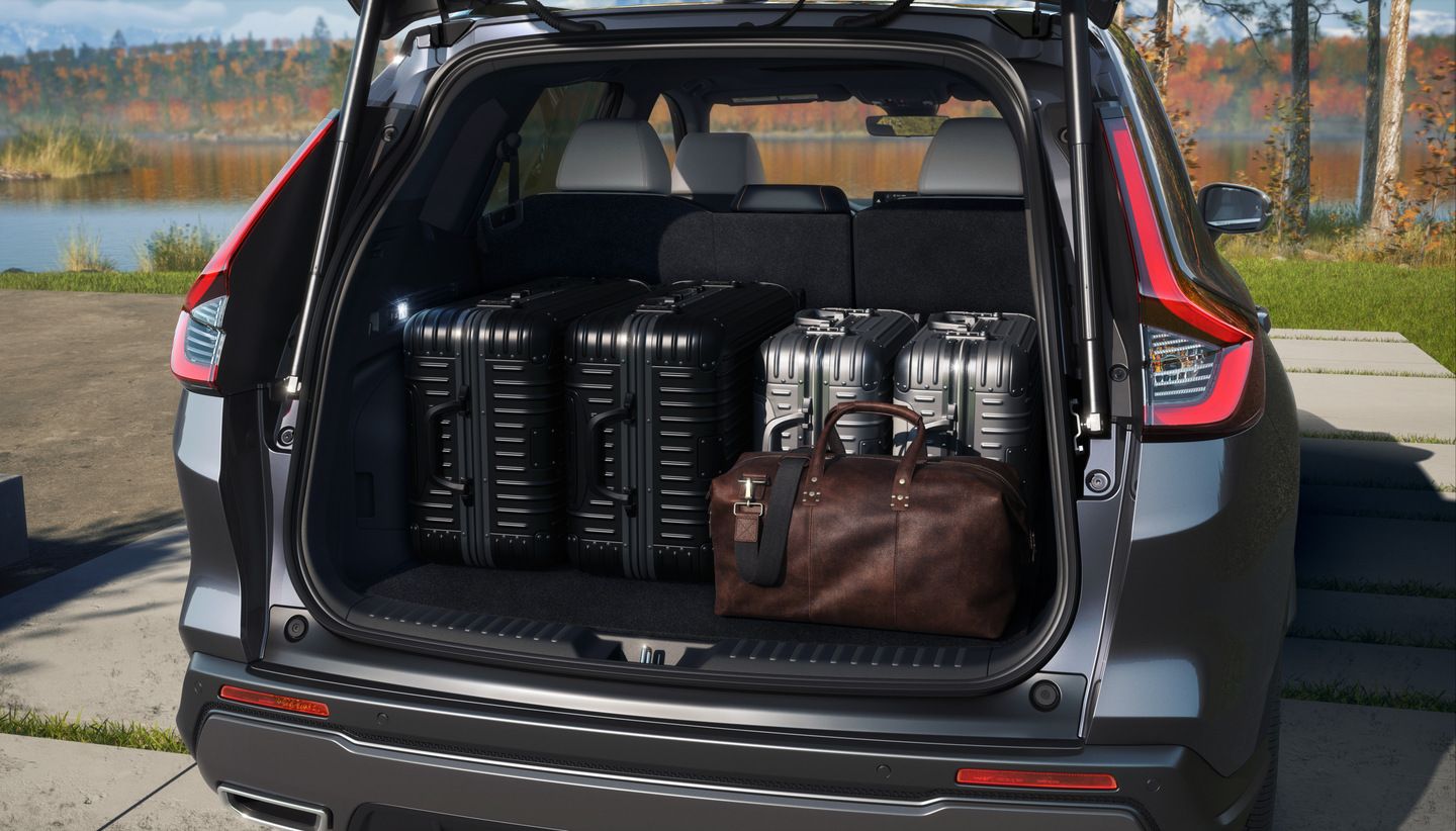 2026 Honda CR-V Sport Touring Hybrid - open trunk of a Honda CR-V Sport Touring Hybrid showing cargo space filled with luggage - Orangeville Honda - New car dealership in Orangeville, Ontario