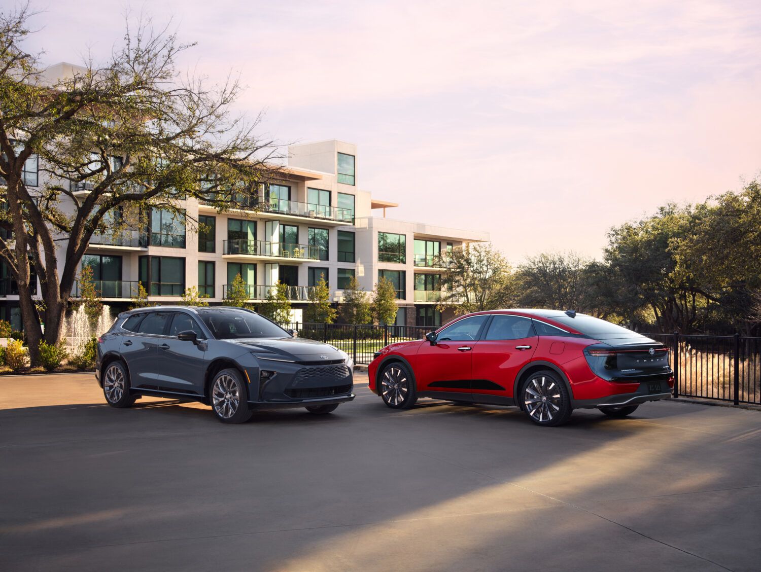 2026 Toyota Crown Signia and Crown Sedan - a grey Toyota Crown Signia SUV and a red Toyota Crown sedan parked in front of a modern building - Goderich Toyota - Toyota new car dealership in Goderich, Ontario