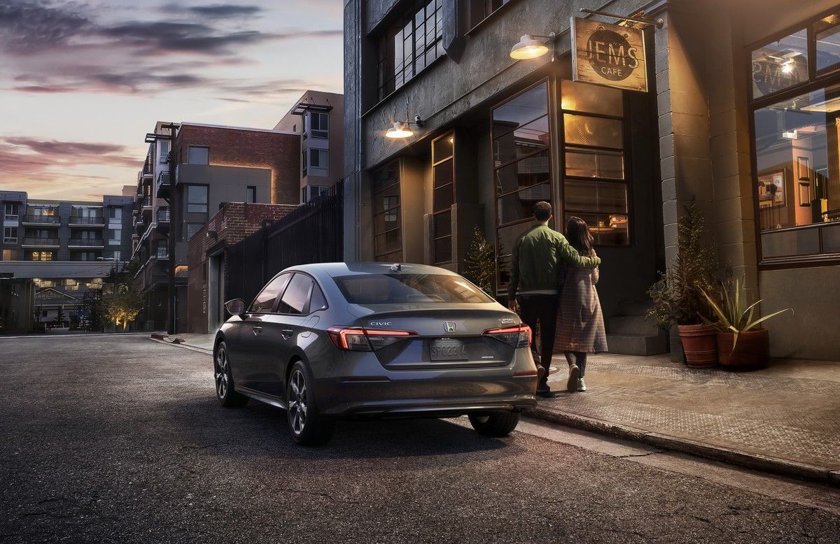 2026 Honda Civic Sedan Sport Touring Hybrid - rear view of a dark grey 2026 Honda Civic Sedan Sport Touring Hybrid parked on a city street - Goderich Honda - Honda new car dealership in Goderich, Ontario