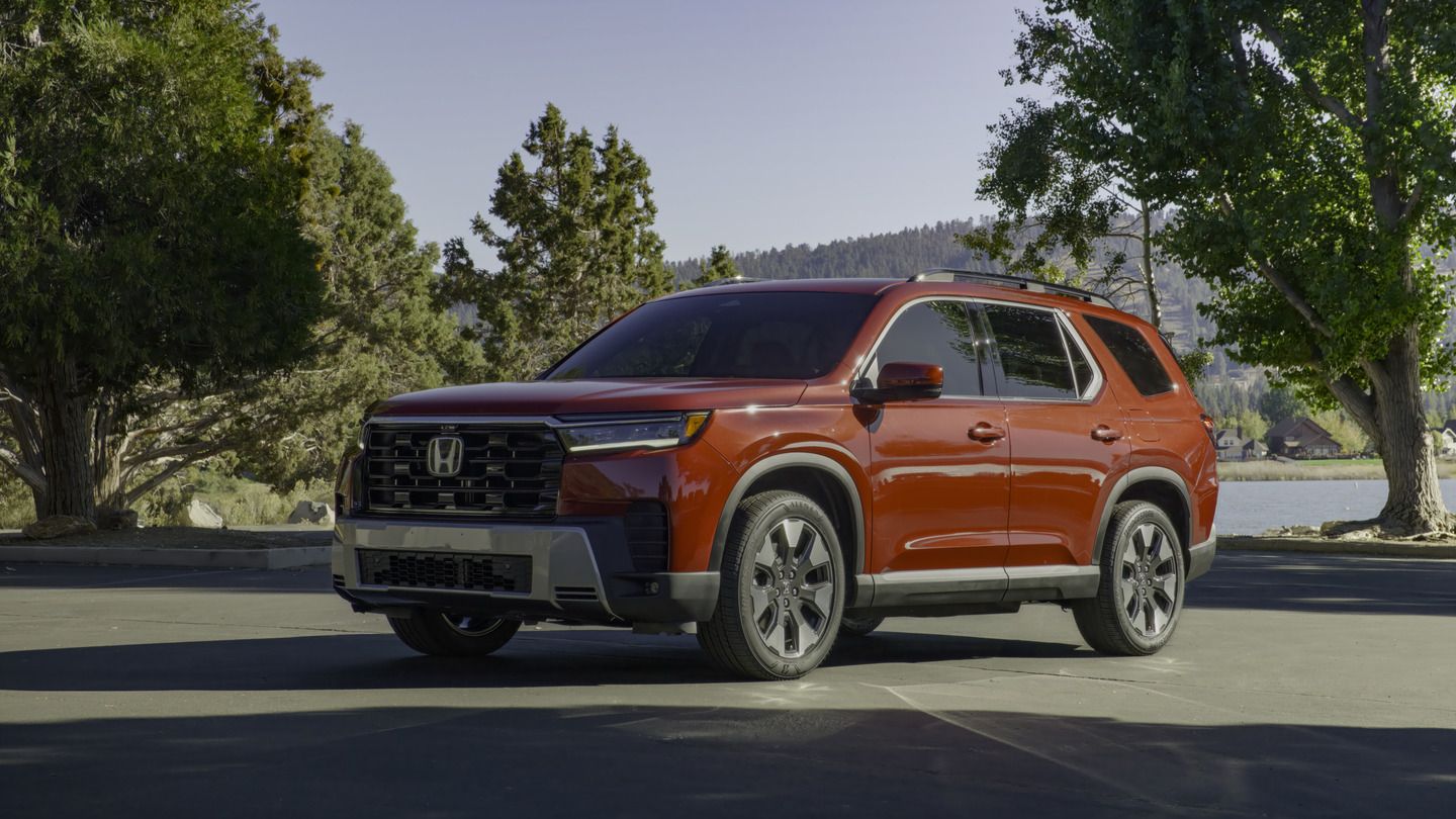 2026 Honda Pilot - a red 2026 Honda Pilot Touring parked in a lot with a lake in the background - Humberview Group - New car dealerships in Ontario