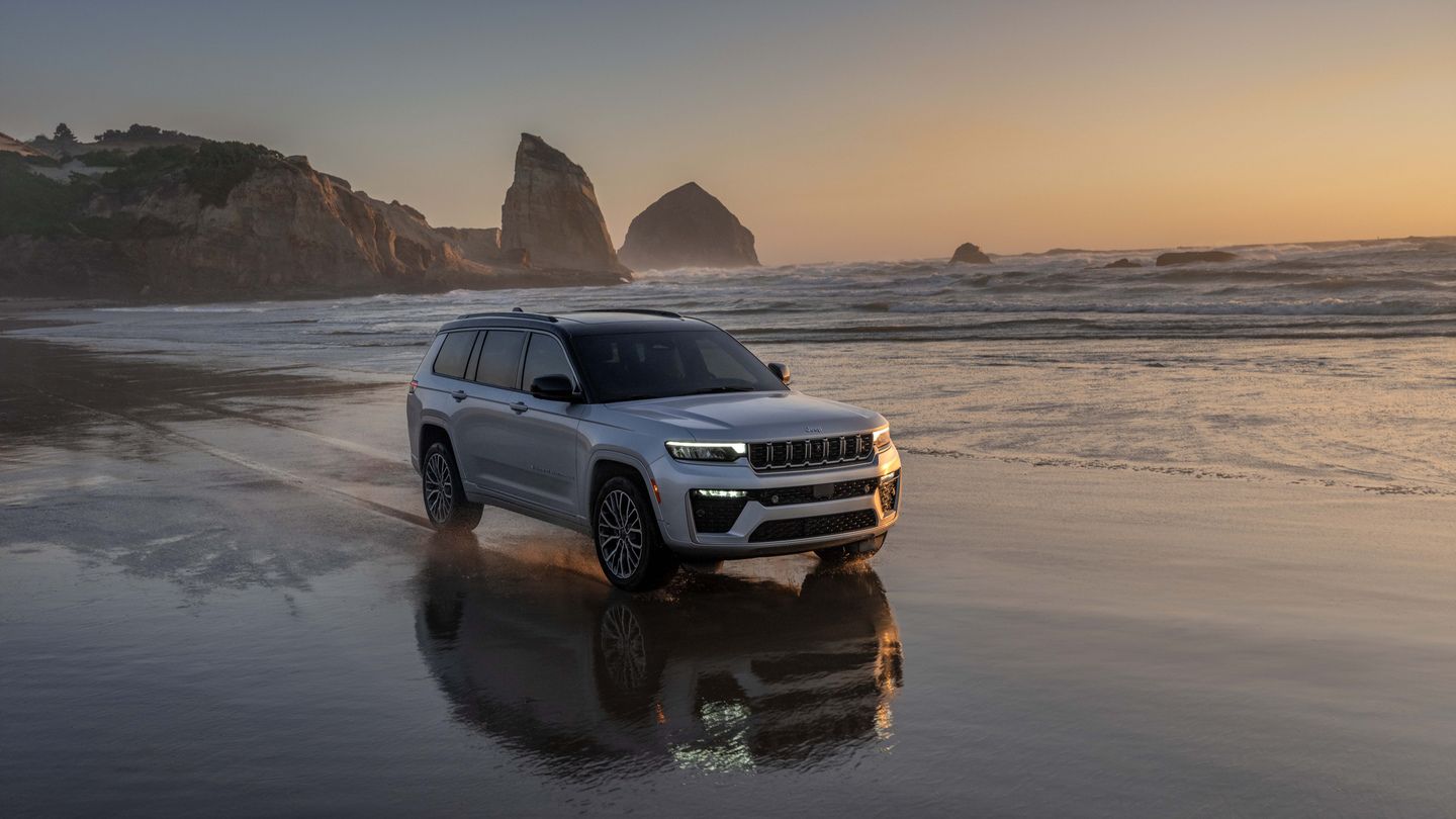 2026 Jeep Grand Cherokee - a silver 2026 Jeep Grand Cherokee driving on a beach at sunset - Humberview Group - New car dealerships in Ontario