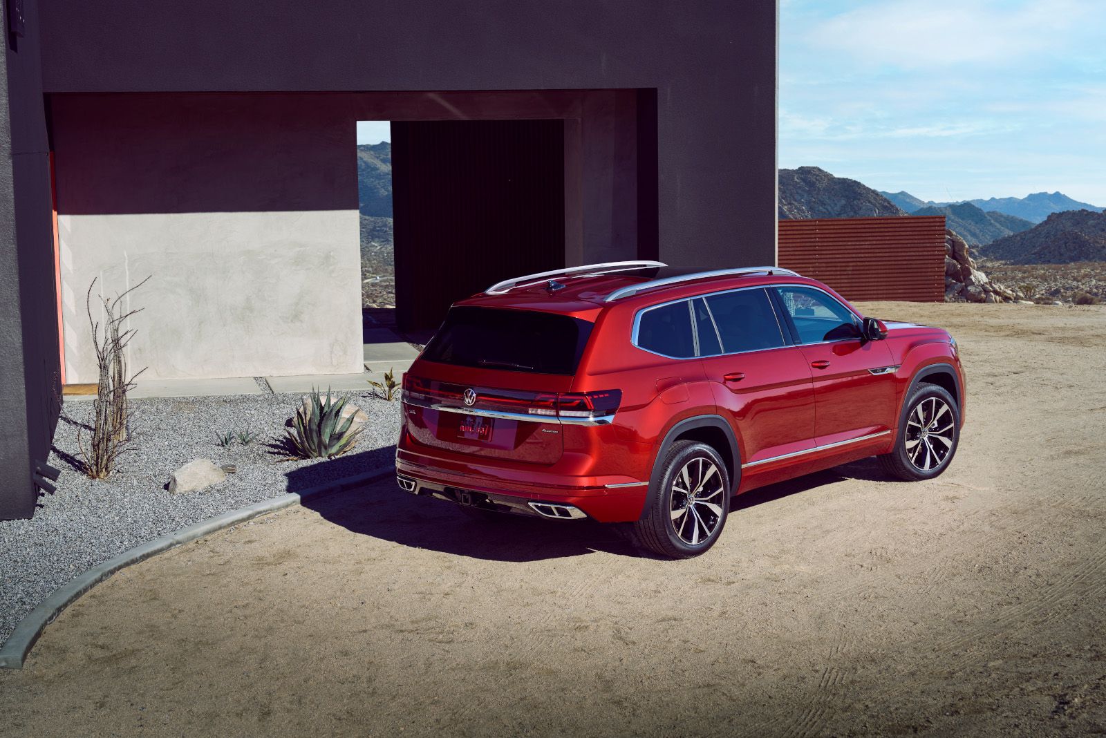 2026 Volkswagen Atlas - a red 2026 Volkswagen Atlas parked in front of a modern desert home - Humberview Group - New car dealerships in Ontario