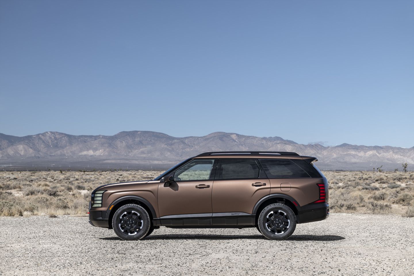 2026 Hyundai Palisade - a brown 2026 Hyundai Palisade XRT shown from the side in a desert landscape - Humberview Group - New car dealerships in Ontario