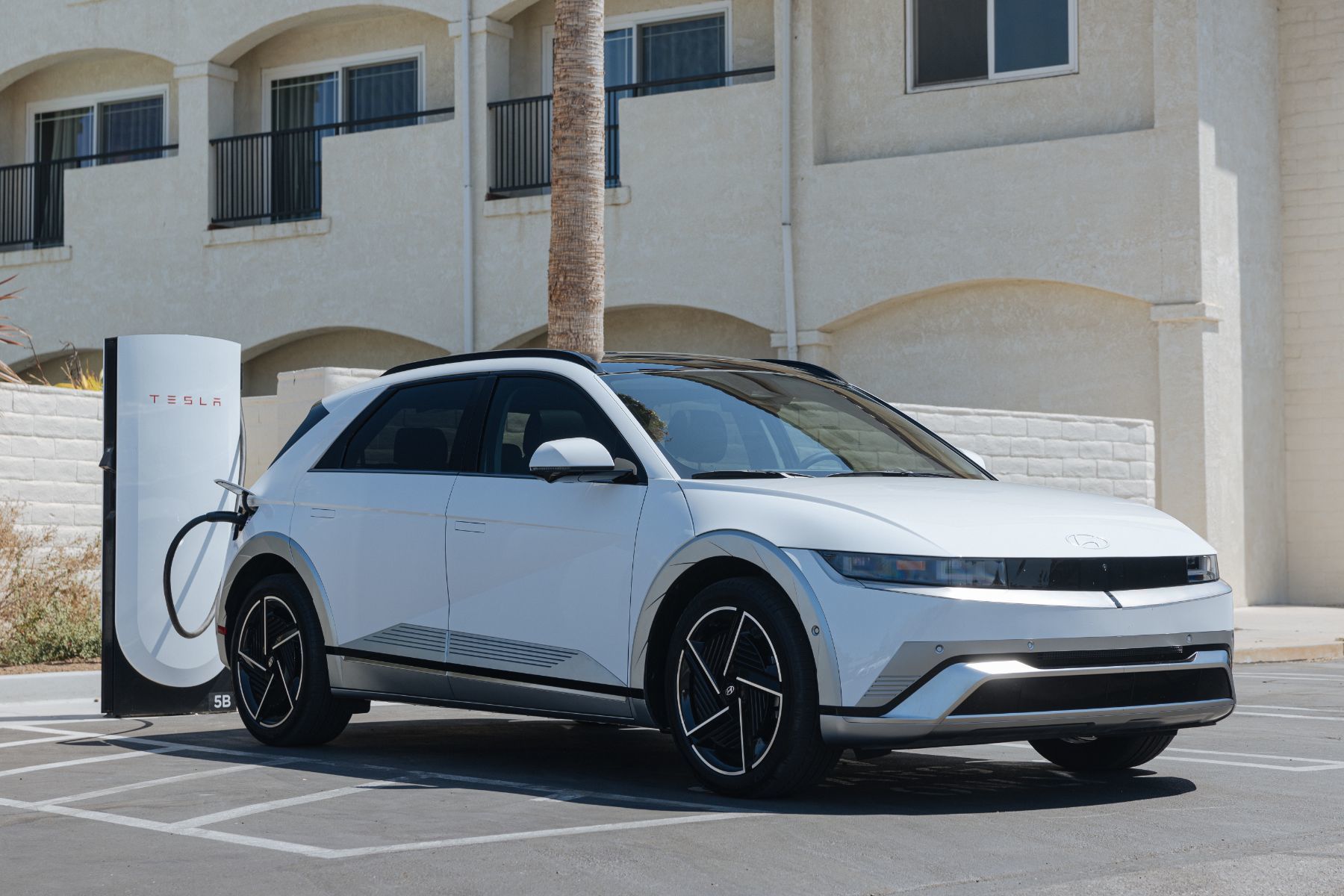 2026 Hyundai Ioniq 5 - a white 2026 Hyundai Ioniq 5 Limited charging at a charging station - Humberview Group - New car dealerships in Ontario
