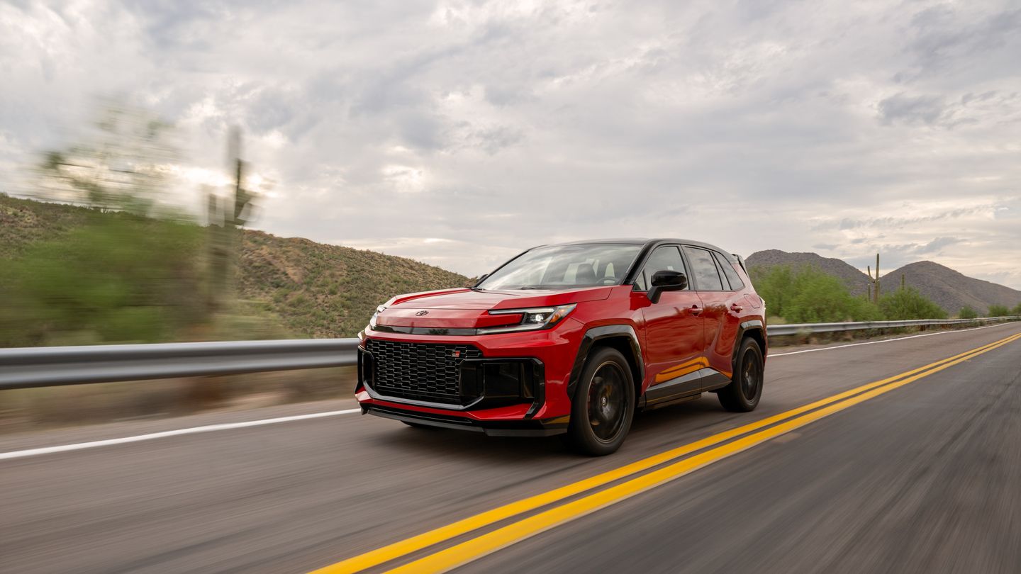 2026 Toyota RAV4 PHEV - a red 2026 Toyota RAV4 PHEV GR Sport driving on a highway through a desert landscape - Goderich Toyota - New car dealership in Goderich, Ontario
