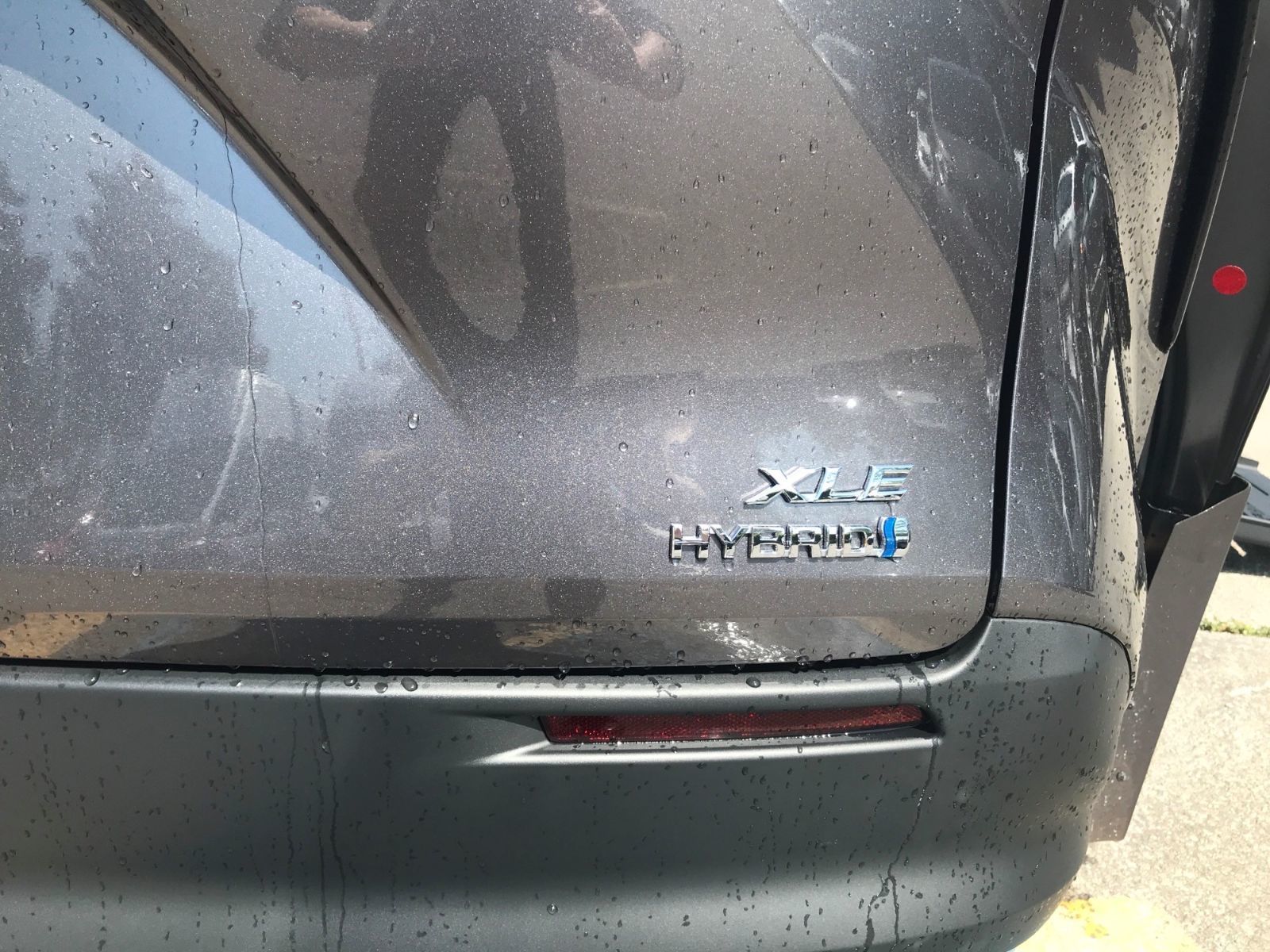 2026 Toyota Sienna - close-up of the XLE Hybrid emblem on the rear of a charcoal 2026 Toyota Sienna - Courtland Mobility - Accessible car dealership in Burlington, Ontario