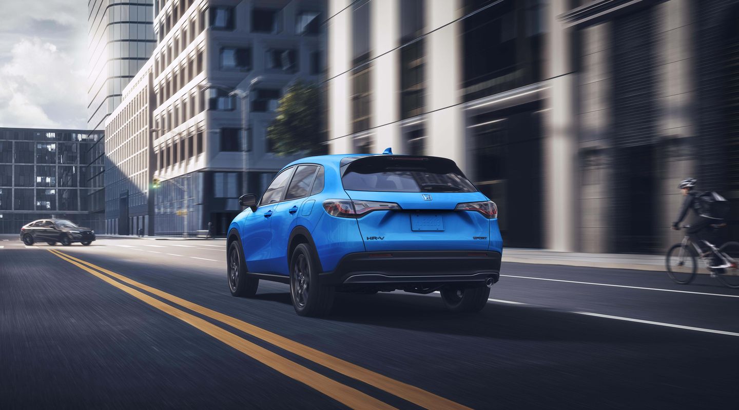 2026 Honda HR-V - rear-quarter view of a blue 2026 Honda HR-V driving through a city - Orangeville Honda - New car dealership in Orangeville, Ontario