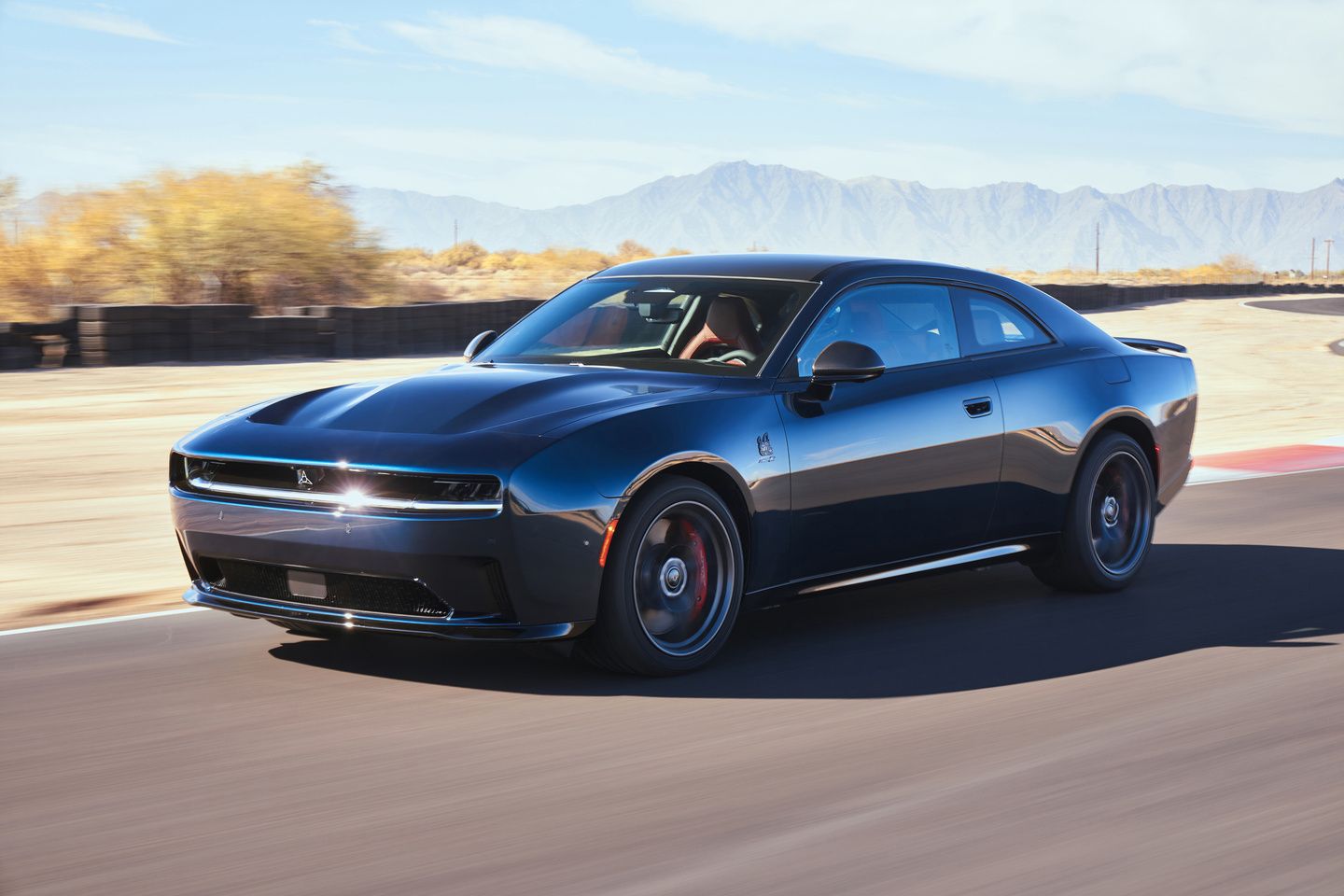 2026 Dodge Charger - A dark blue Dodge Charger Daytona driving on a race track - Humberview Group - Dodge new car dealerships in Ontario