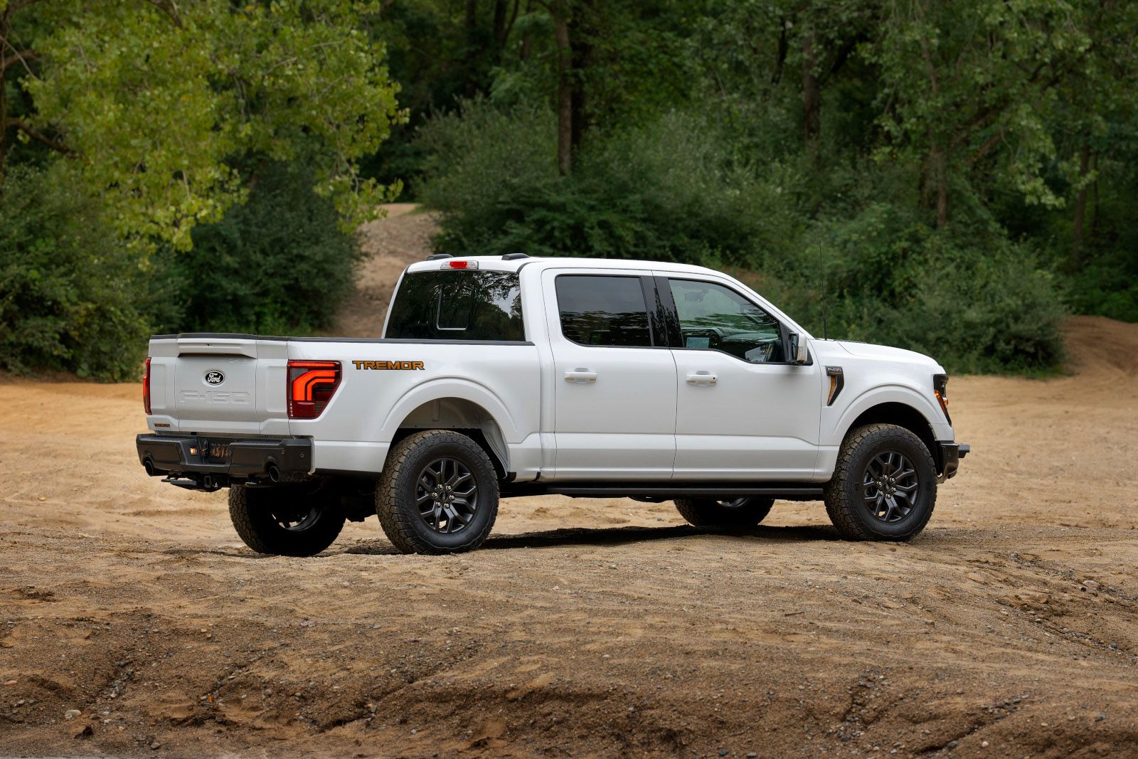 2026 Ford F-150 Tremor - rear three-quarter view of a white off-road truck parked on a dirt trail - Mayfield Ford - New car dealership in Brampton, Ontario