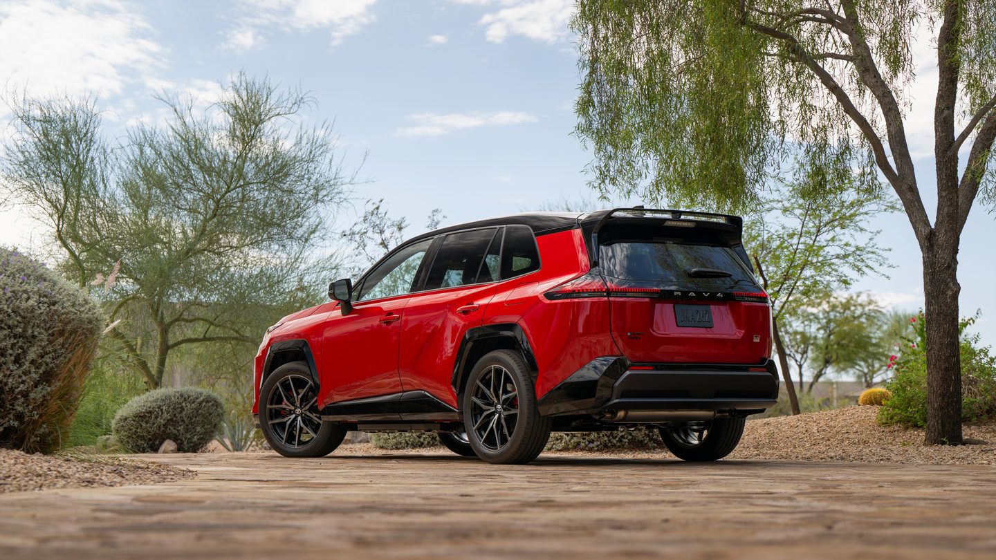 2026 Toyota RAV4 PHEV - Rear three-quarter view of a Supersonic Red Toyota RAV4 PHEV GR Sport parked on a paved driveway - Goderich Toyota - New car dealership in Goderich, Ontario
