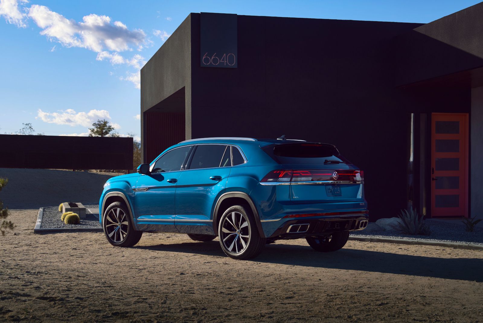 2026 Volkswagen Atlas Cross Sport - rear three-quarter view of a blue 2026 Volkswagen Atlas Cross Sport parked next to a modern dark building - Humberview Volkswagen - New car dealership in Toronto, Ontario