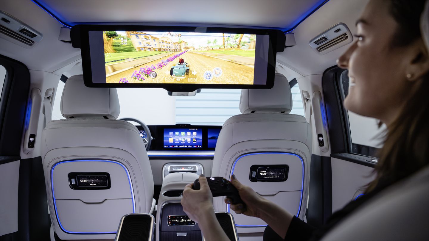 2028 Mercedes-Benz VLE - Interior view from the back seat showing a person using a controller to play a game on the roof-mounted entertainment screen - Mercedes-Benz Brampton - New car dealership in Brampton, Ontario