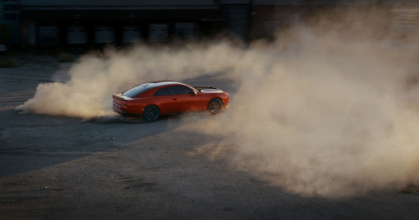 2026 Dodge Charger - aerial view of an orange 2026 Dodge Charger drifting and spinning donuts in a cloud of smoke - Cooksville Dodge - New car dealership in Mississauga, Ontario
