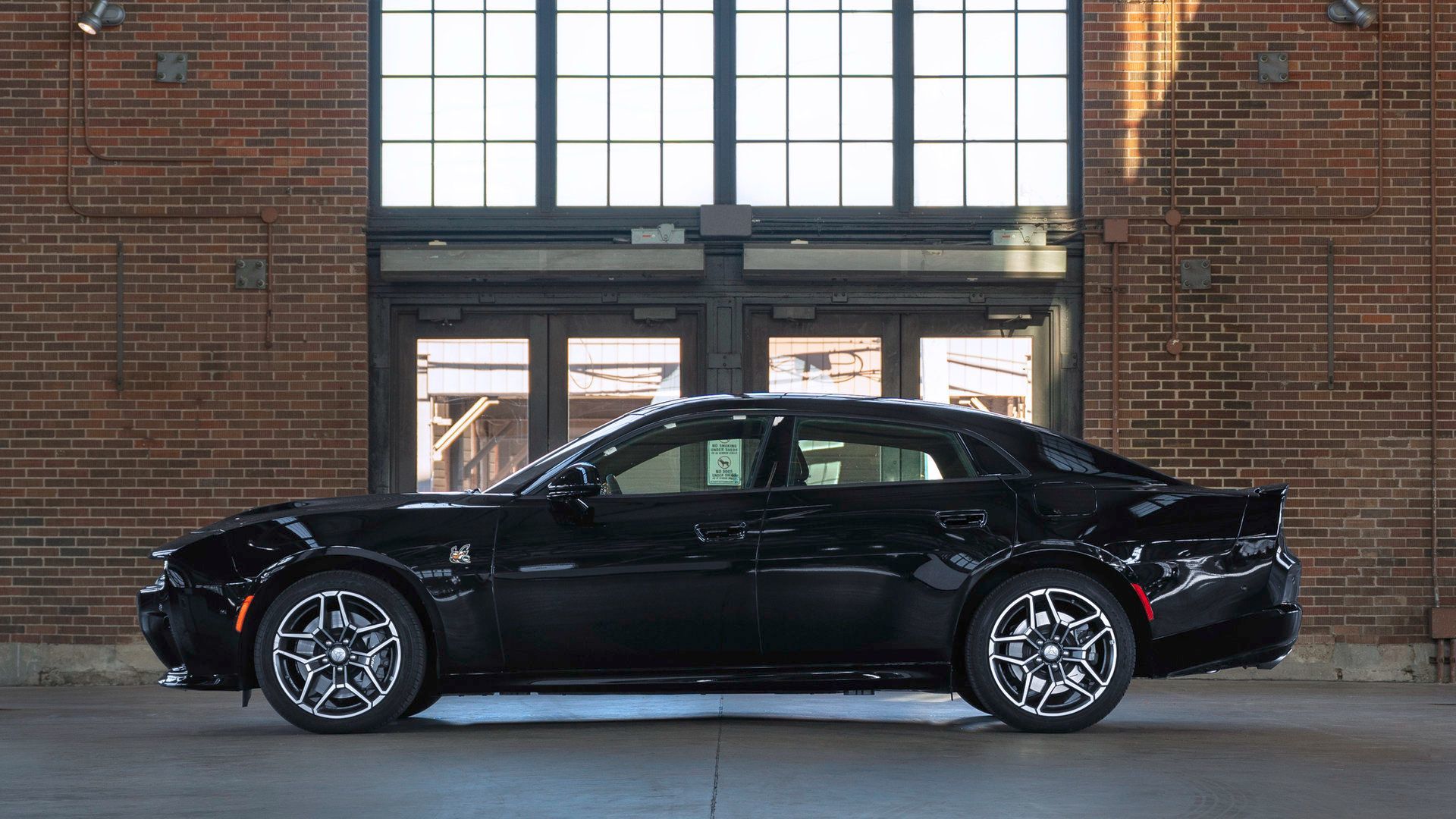 2026 Dodge Charger - clean side profile view of a black four-door 2026 Dodge Charger parked inside a brick garage - Cooksville Dodge - New car dealership in Mississauga, Ontario