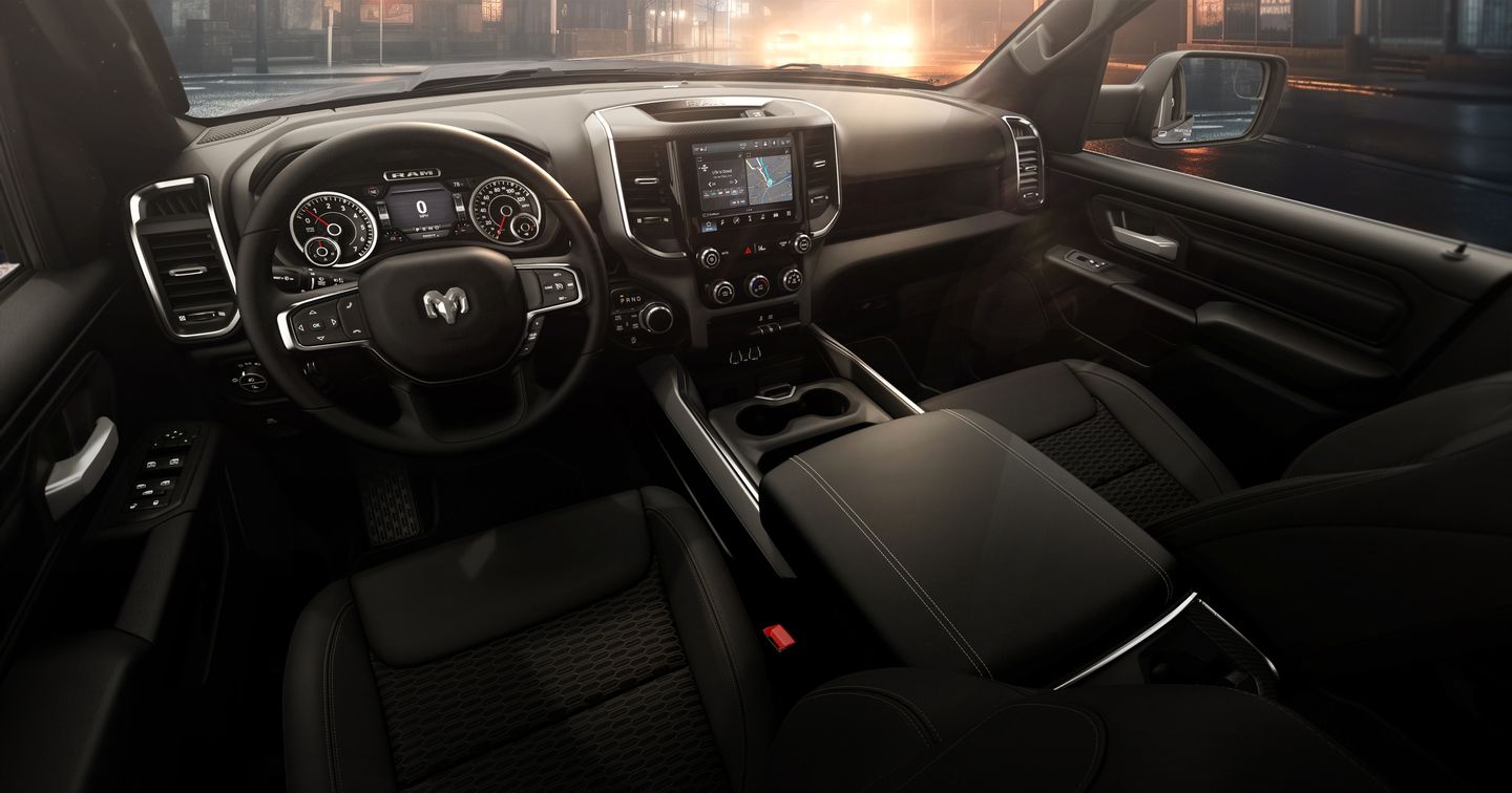 2026 Ram 1500 - interior view of the 2026 Ram 1500's front cabin, dashboard, steering wheel, and center console at dusk - Cooksville Dodge - New car dealership in Mississauga, Ontario