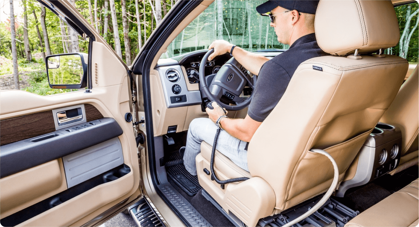 Ford F-150 - interior view of a Ford F-150 pickup truck with a driver utilizing a hand control steering device - Courtland Mobility - Wheelchair accessible car dealership in Burlington, Ontario