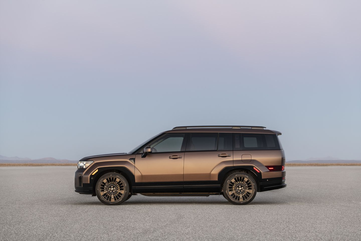 2026 Hyundai Santa Fe - Side profile view of a bronze Hyundai Santa Fe parked on a flat desert surface - Humberview Group - new car dealerships in Ontario