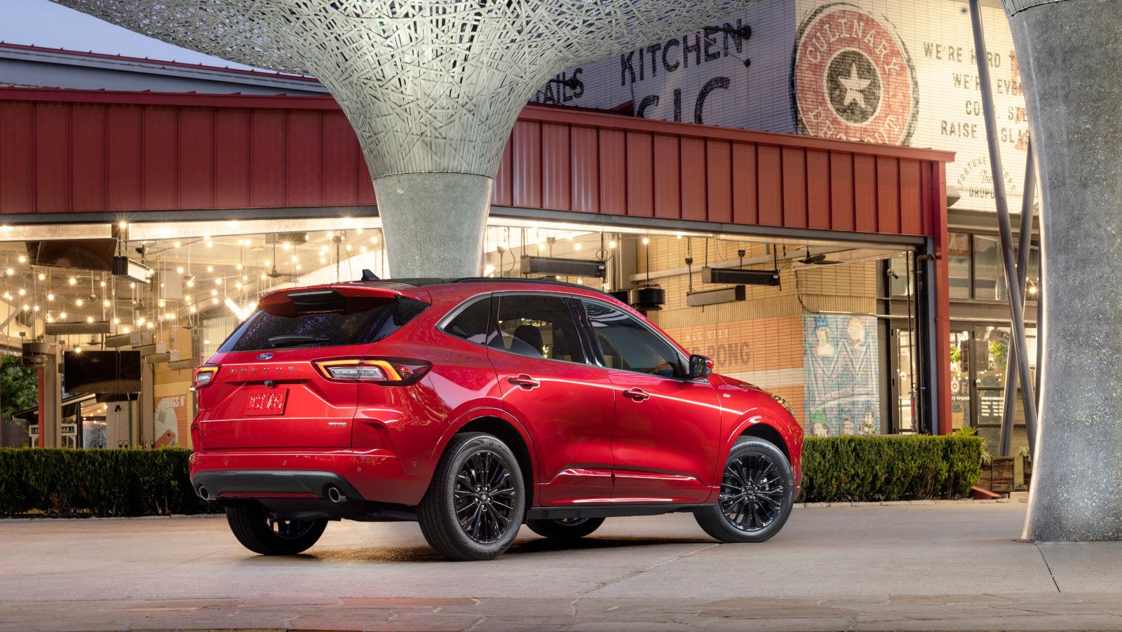 2026 Ford Escape - Rear three-quarter view of a red Ford Escape parked in an urban plaza setting at night - Humberview Group - new car dealerships in Ontario