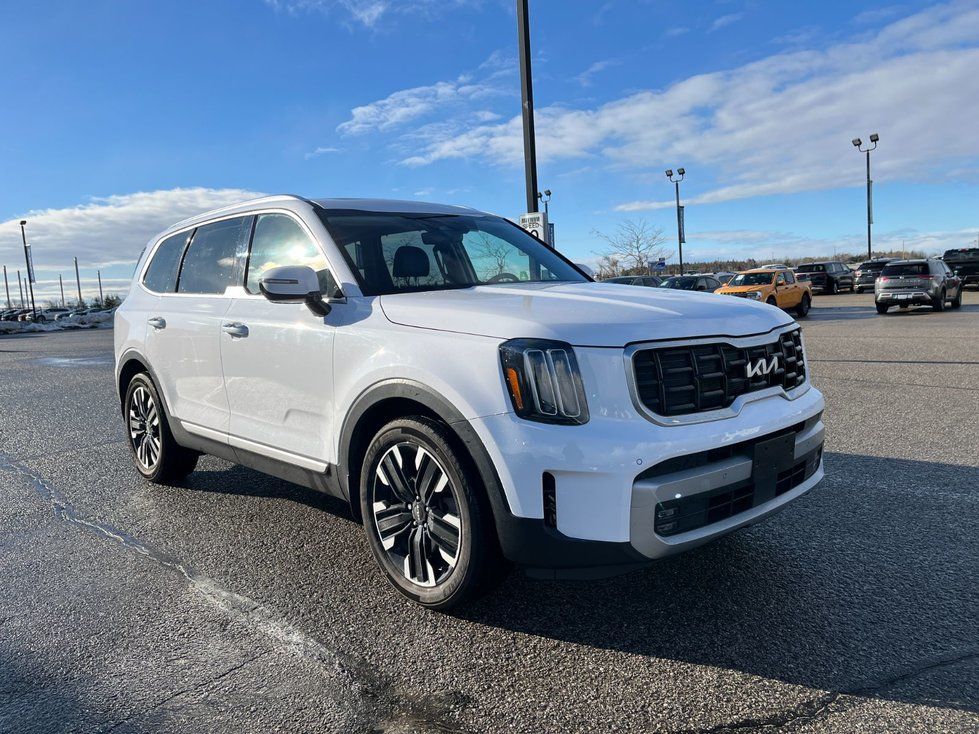 Kia Telluride - a front three-quarter view of a white Kia Telluride parked on a dealership lot under a blue sky - AutoPark Barrie - Used car dealership in Barrie, Ontario