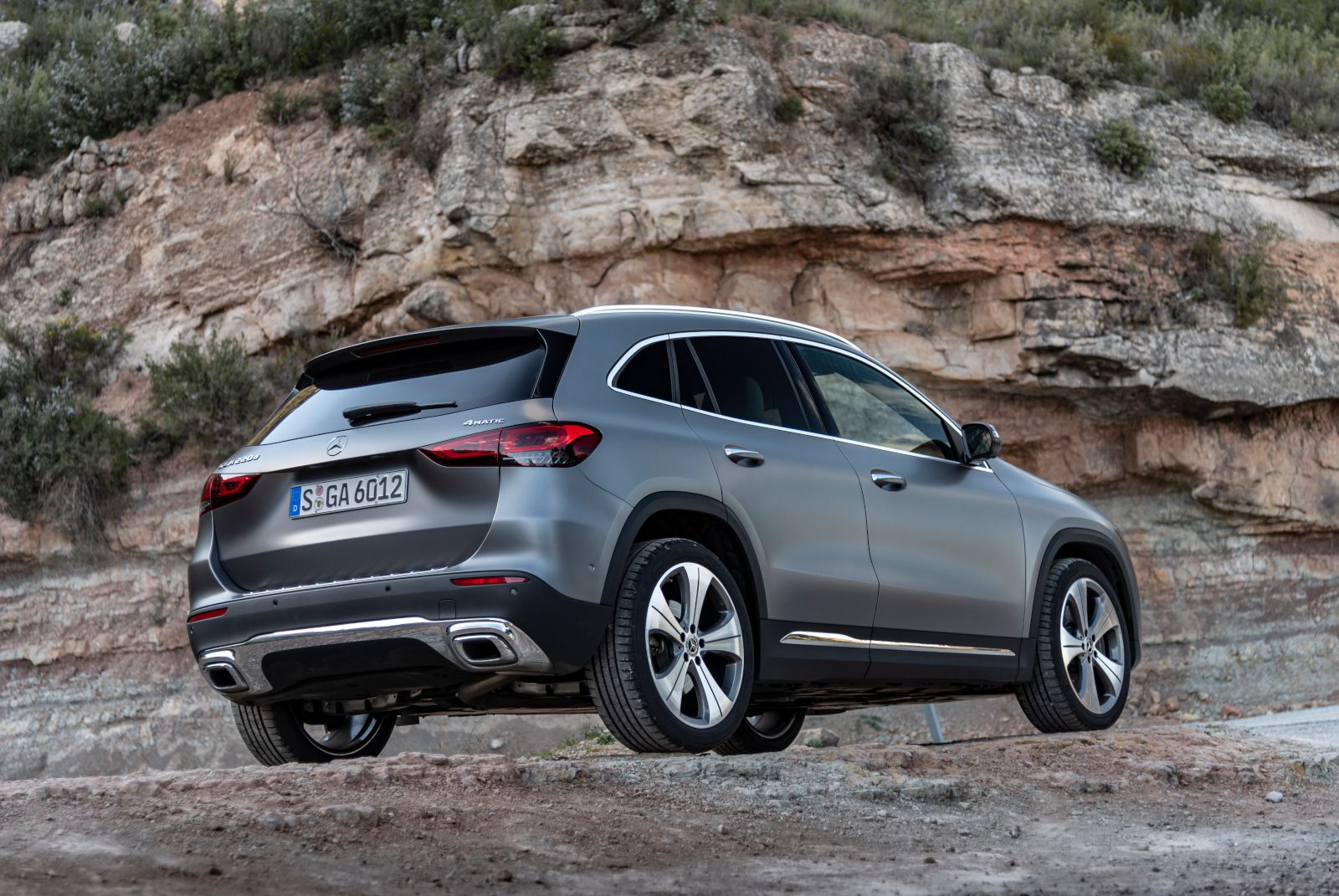 2026 Mercedes-Benz GLA - rear three-quarter view of a matte grey 2026 Mercedes-Benz GLA parked on a rocky hillside - Mercedes-Benz Brampton - New car dealership in Brampton, Ontario