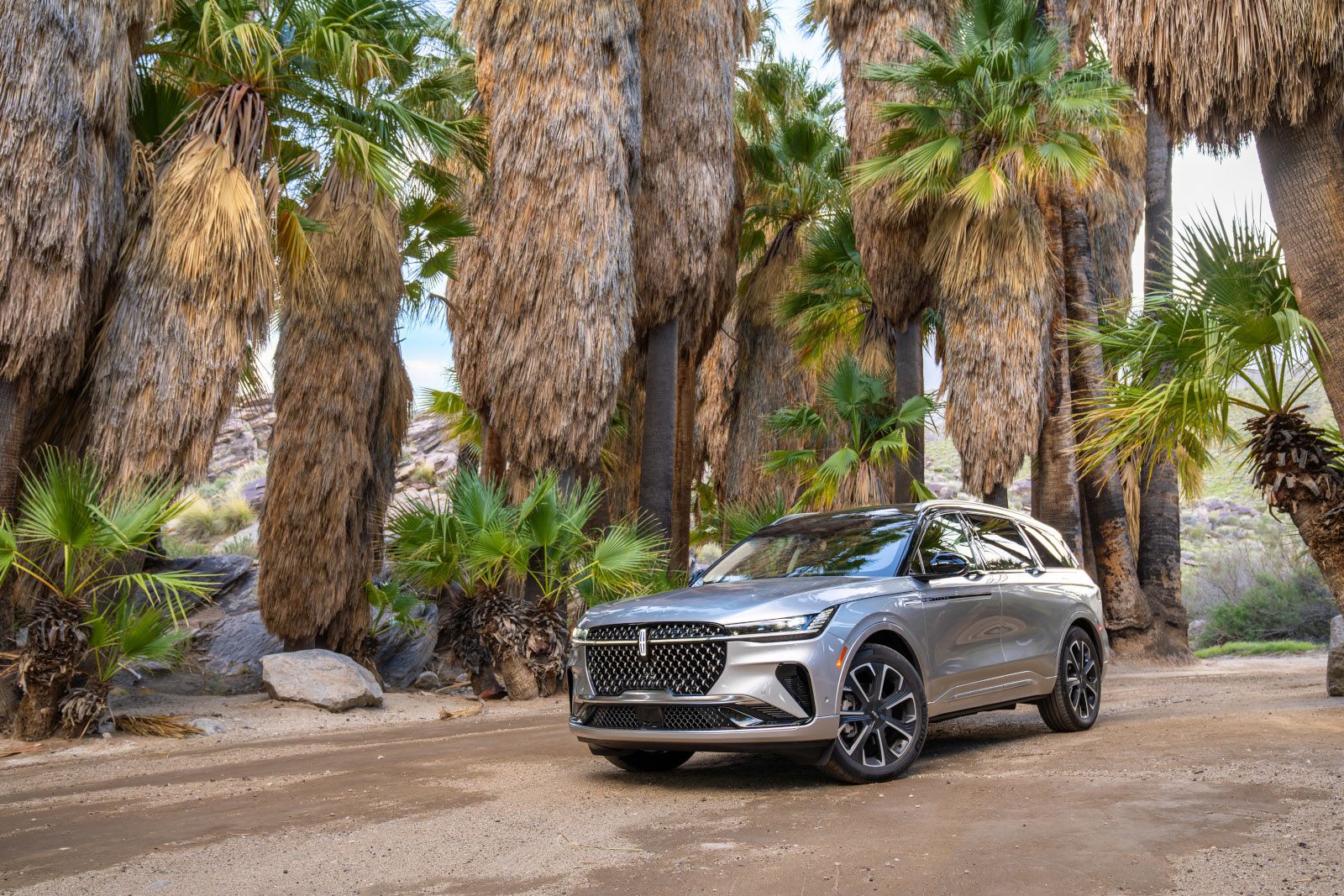 2026 Lincoln Nautilus - Front three-quarter view of a silver 2026 Lincoln Nautilus parked on a dirt path surrounded by palm trees - Mayfield Lincoln - Lincoln car dealership in Brampton, Ontario