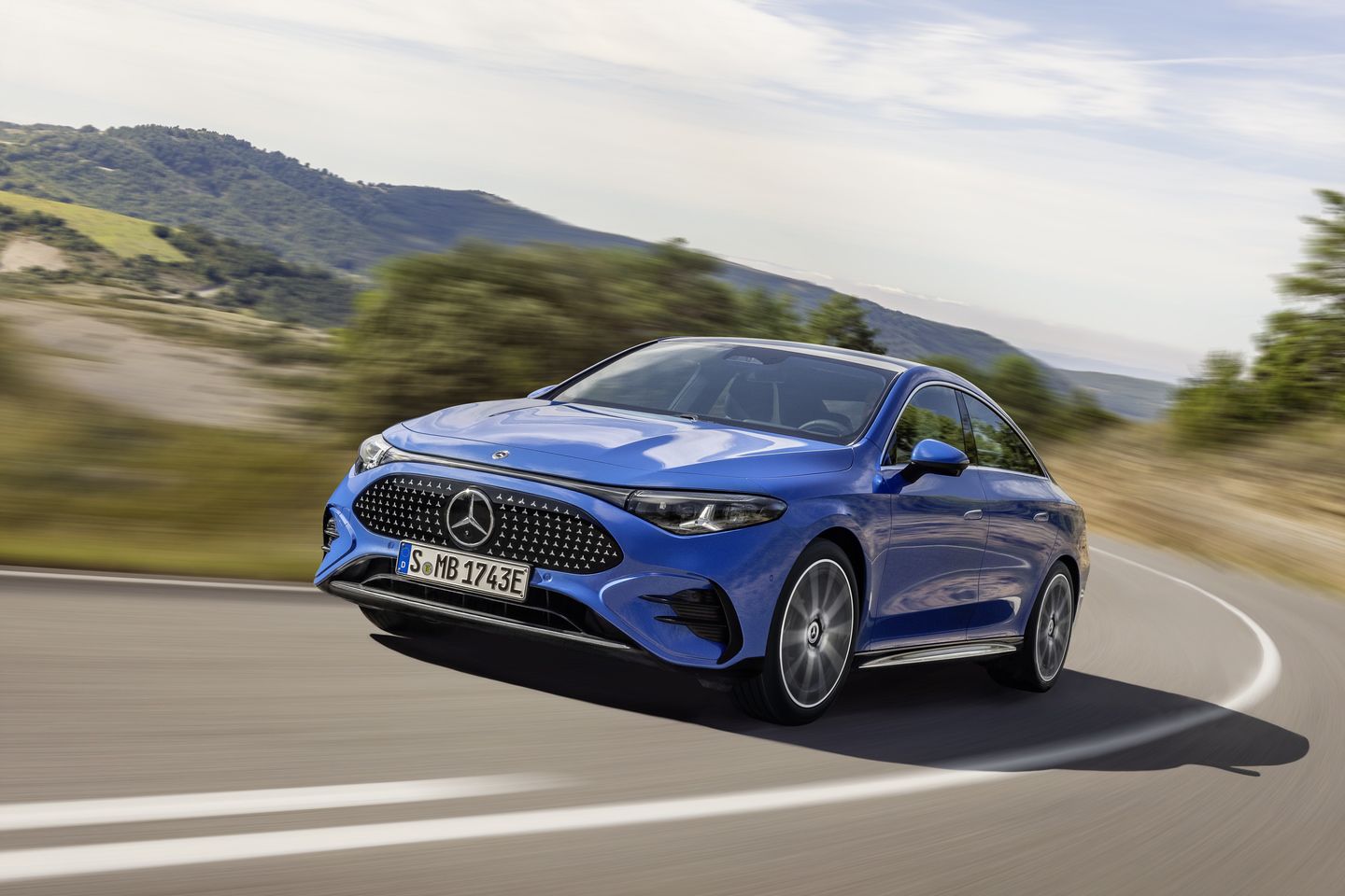 2027 Mercedes-Benz CLA EV - Front three-quarter view of a blue Mercedes-Benz CLA EV driving on a winding road - Humberview Group - New car dealerships in Ontario