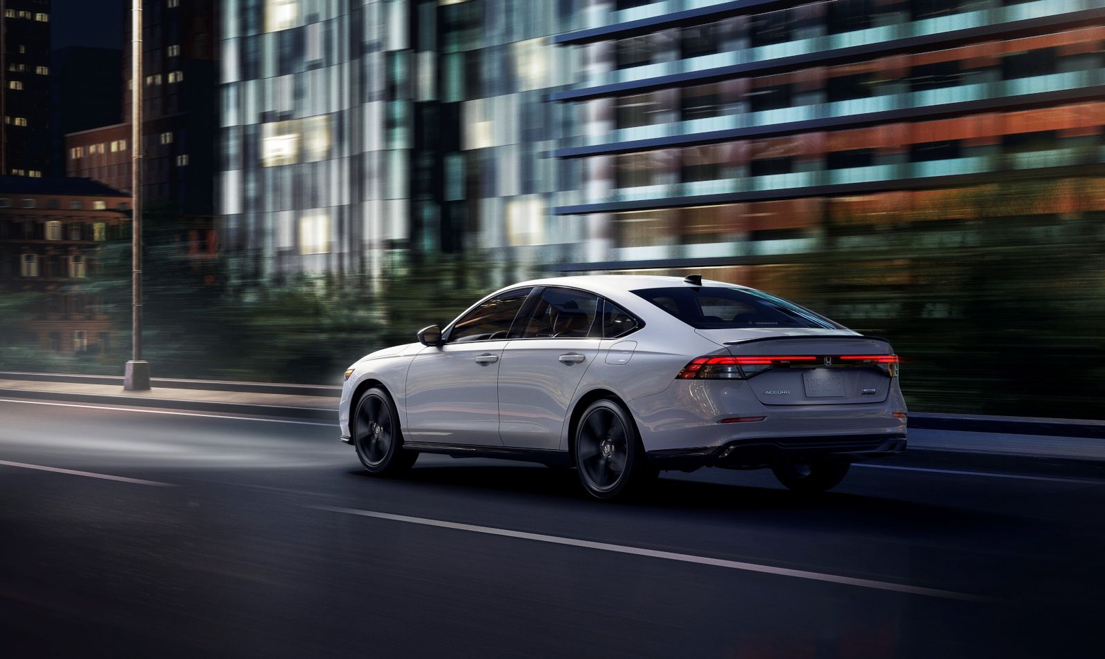 2026 Honda Accord - A white Honda Accord driving on a street at night with motion blur in the background - Orangeville Honda - Honda car dealership in Orangeville, Ontario