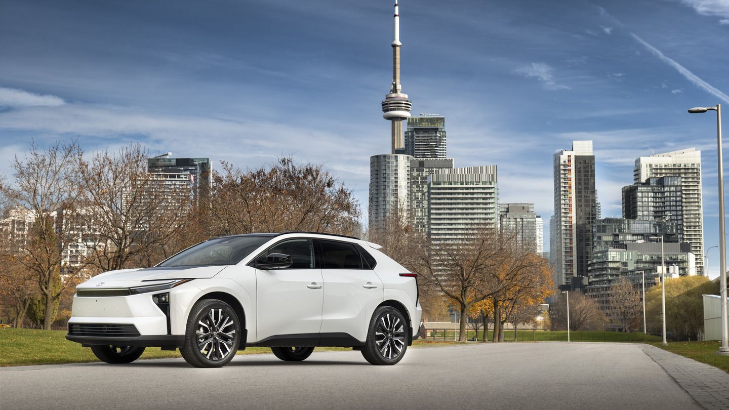2026 Toyota bZ - A white 2026 Toyota bZ parked on a paved path with a city skyline backdrop - Goderich Toyota - New car dealership in Goderich, Ontario