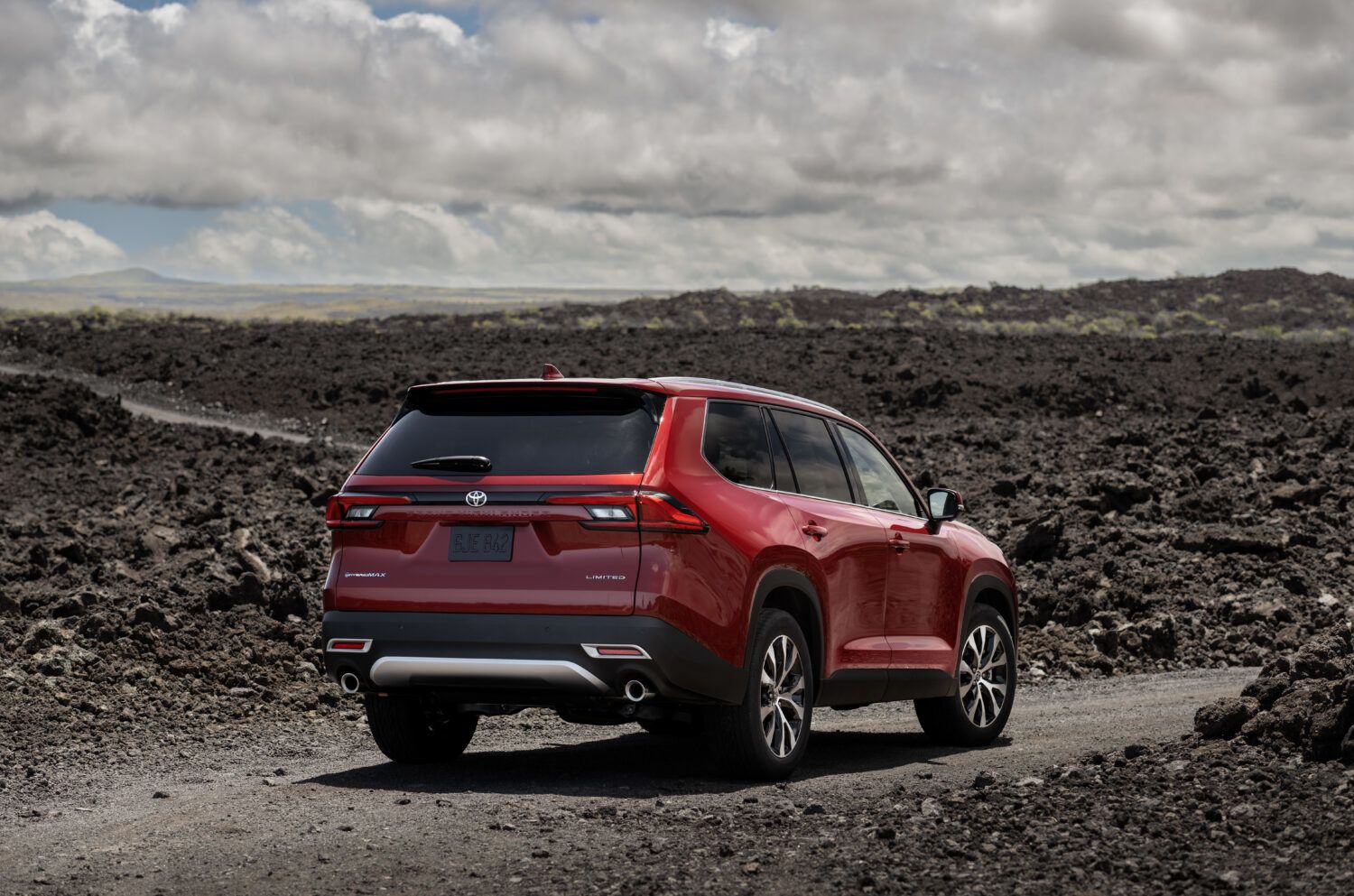 2026 Toyota Grand Highlander - rear view of a red 2026 Toyota Grand Highlander parked on a dirt trail in a volcanic landscape - Georgetown Toyota - Toyota new car dealership in Georgetown, Ontario
